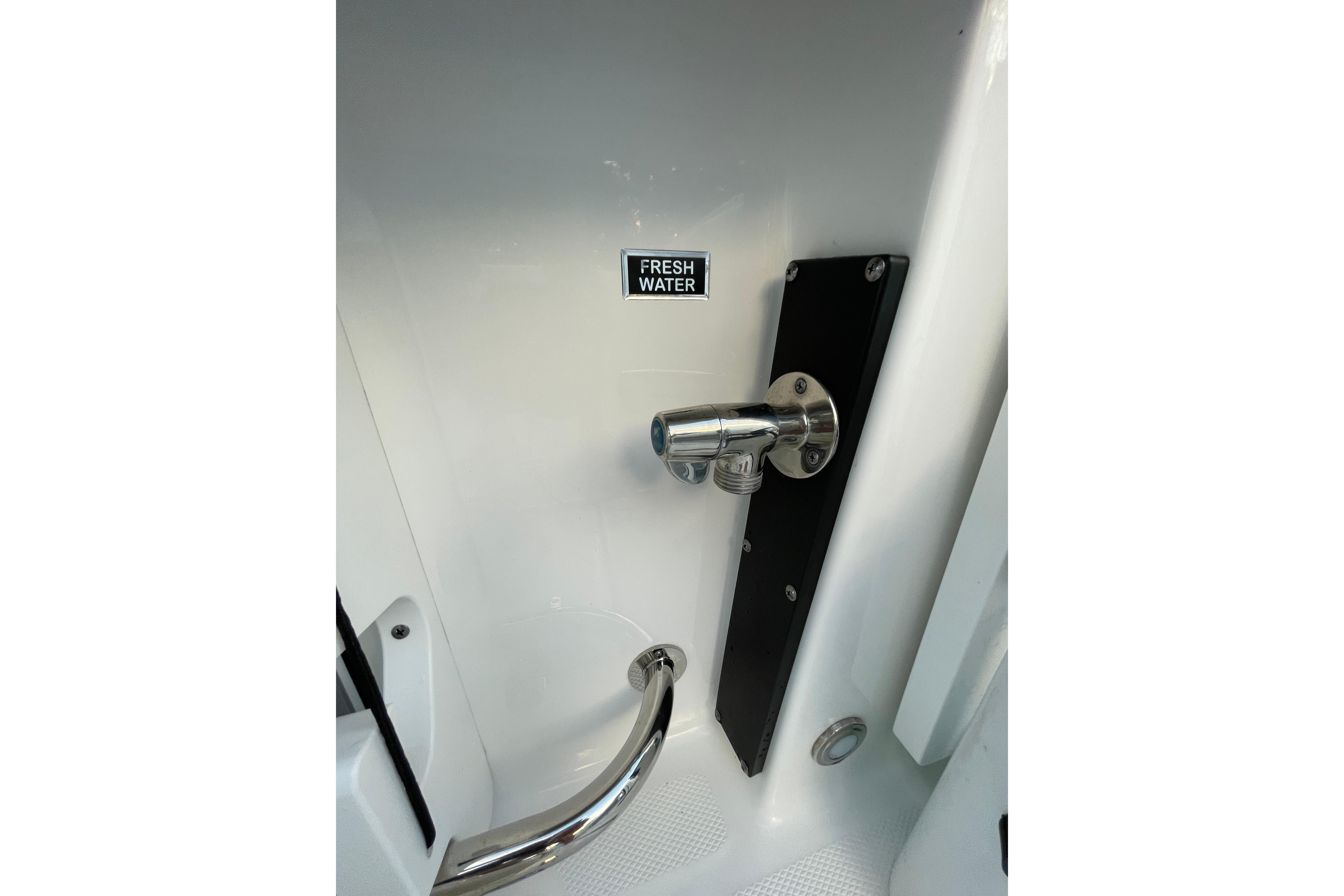 Freshwater outlet on 2022 Blackfin 252 CC boat, featuring sleek chrome finish.