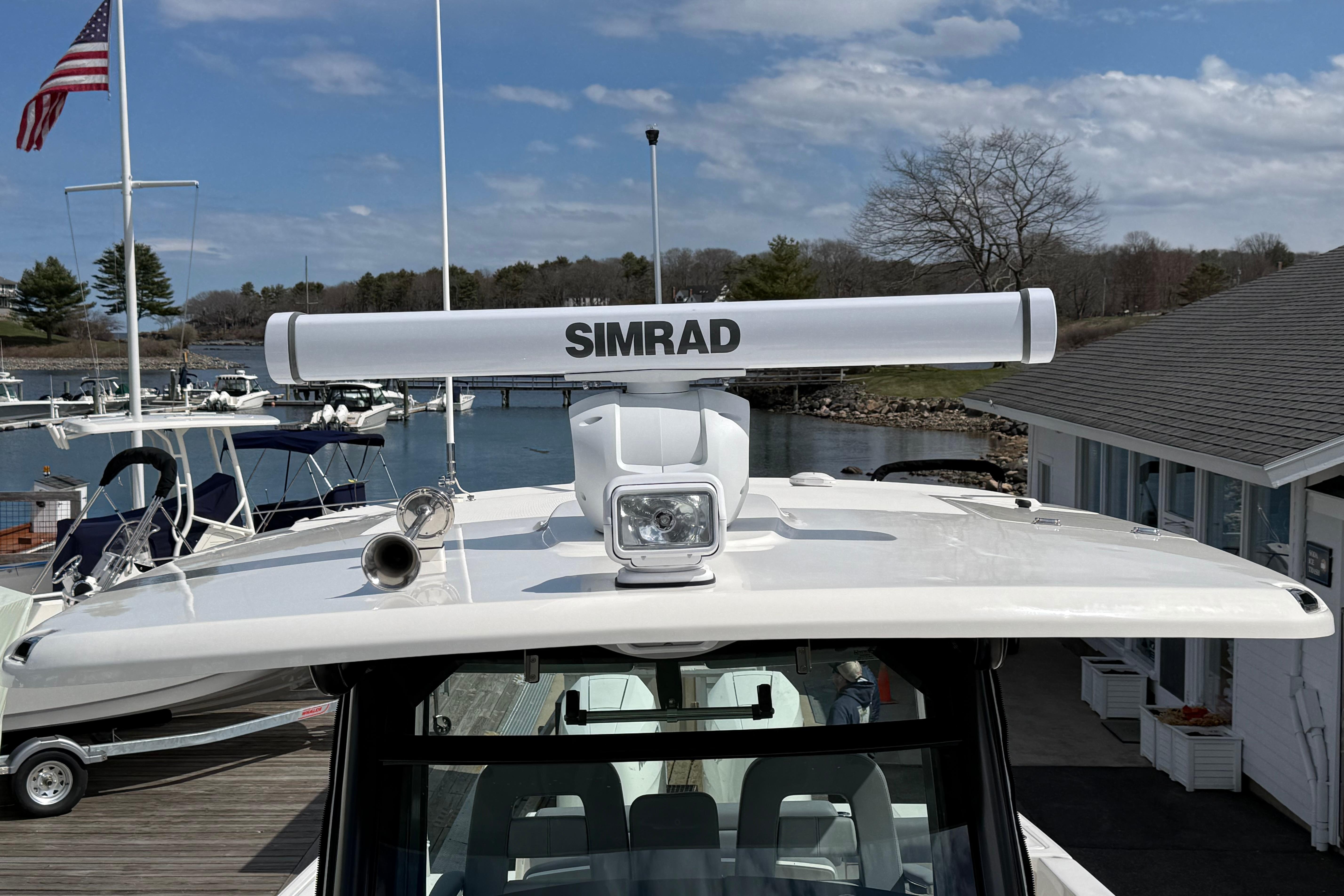 2026 Boston Whaler 330 Outrage with Simrad radar, docked at marina under blue sky.