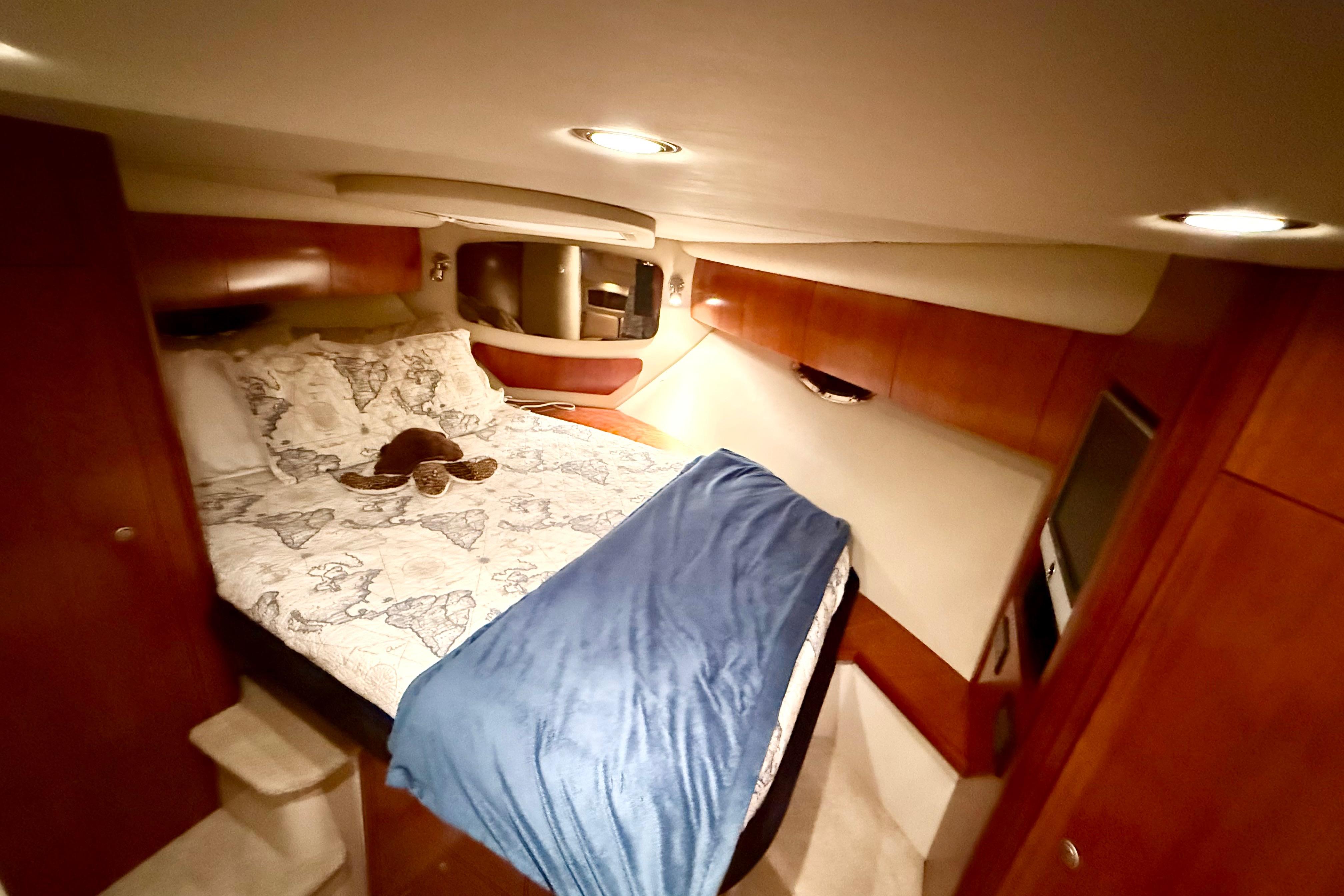Luxurious cabin interior of 2011 Cruisers Yachts 390 Sports Coupe with cozy bedding.