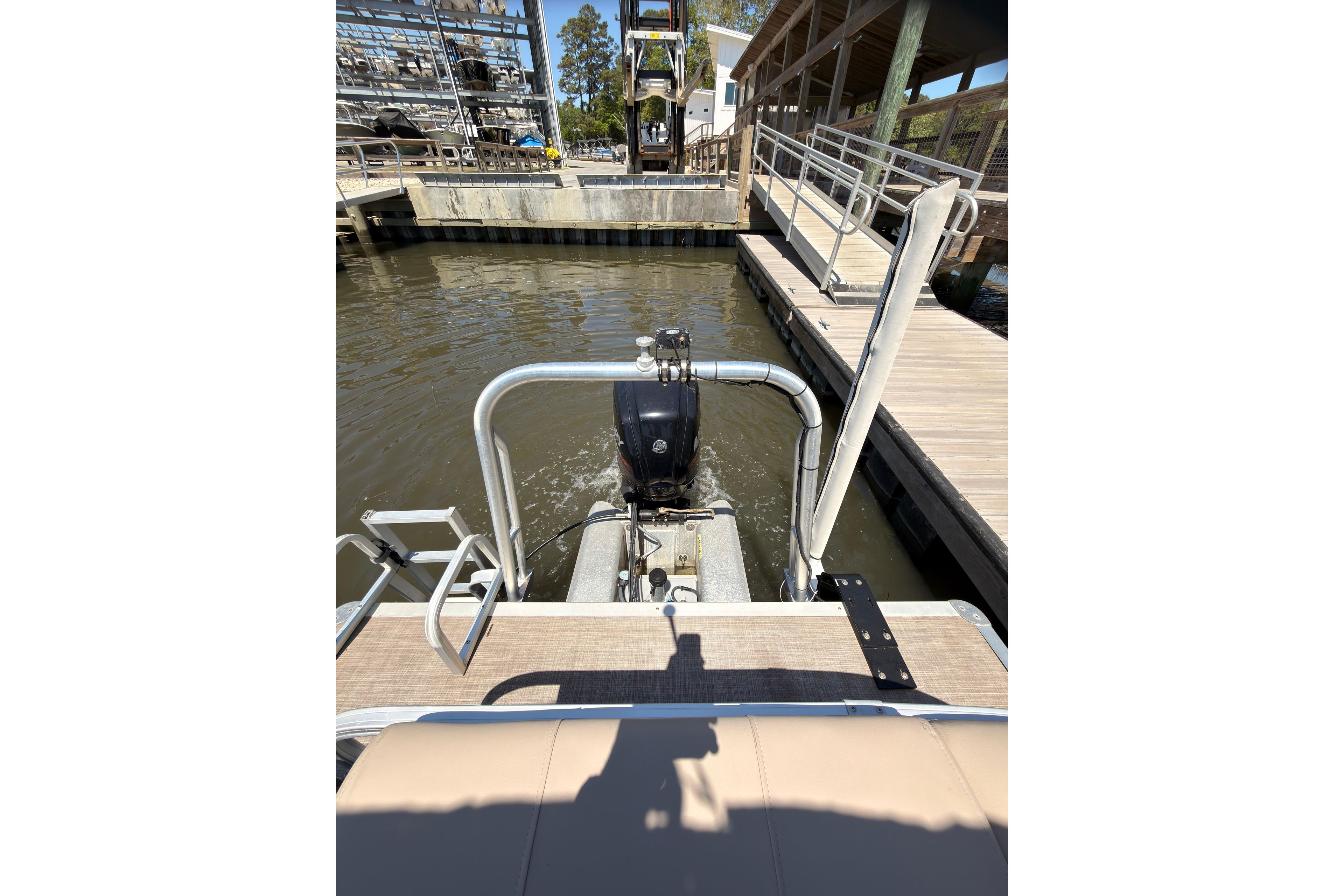 2019 SUNTRACKER Party Barge 20 DLX at dock, rear view with motor and water.