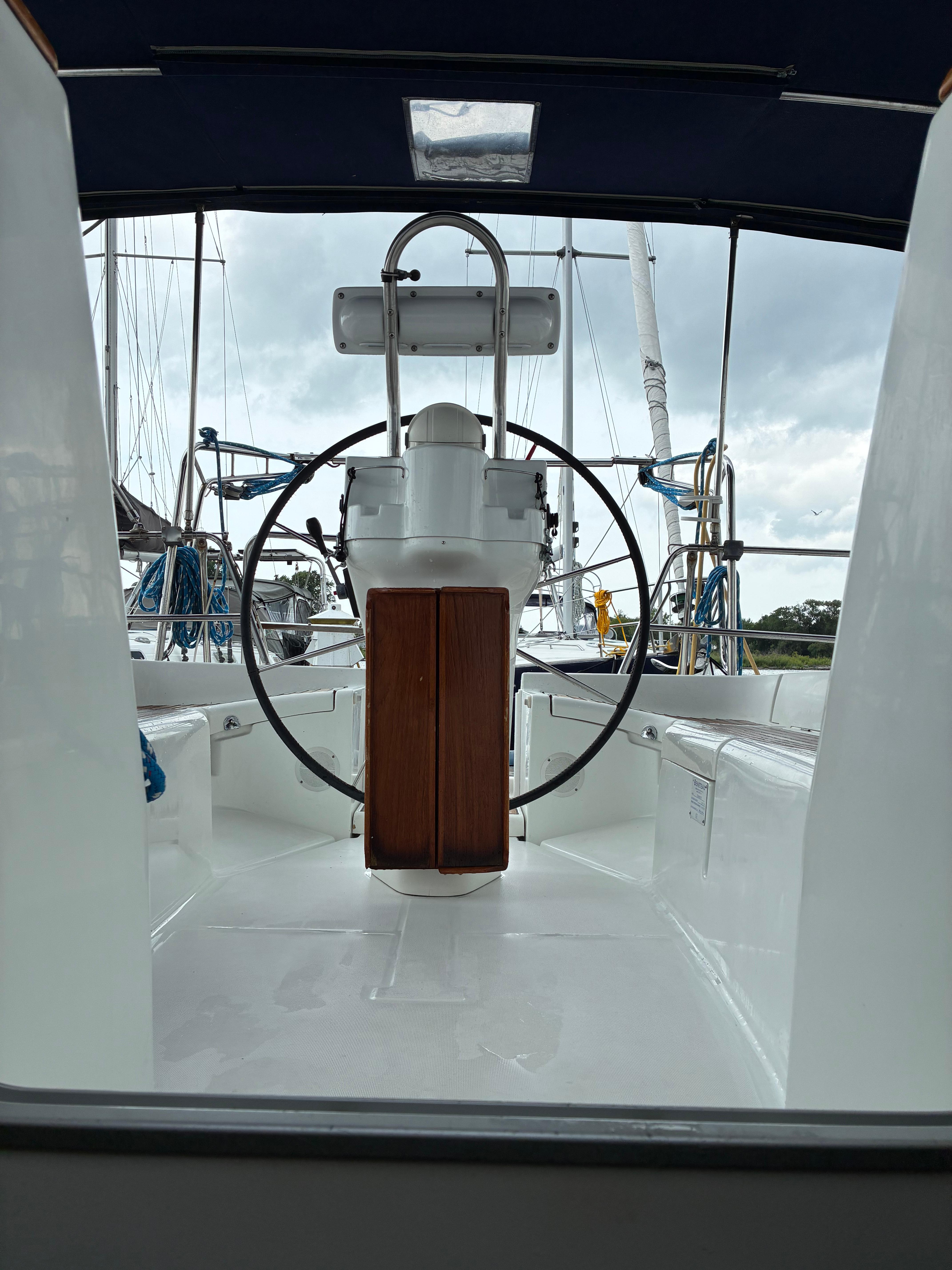 Cockpit view of 2003 Beneteau Oceanis Clipper 393 sailboat with steering wheel and seating.