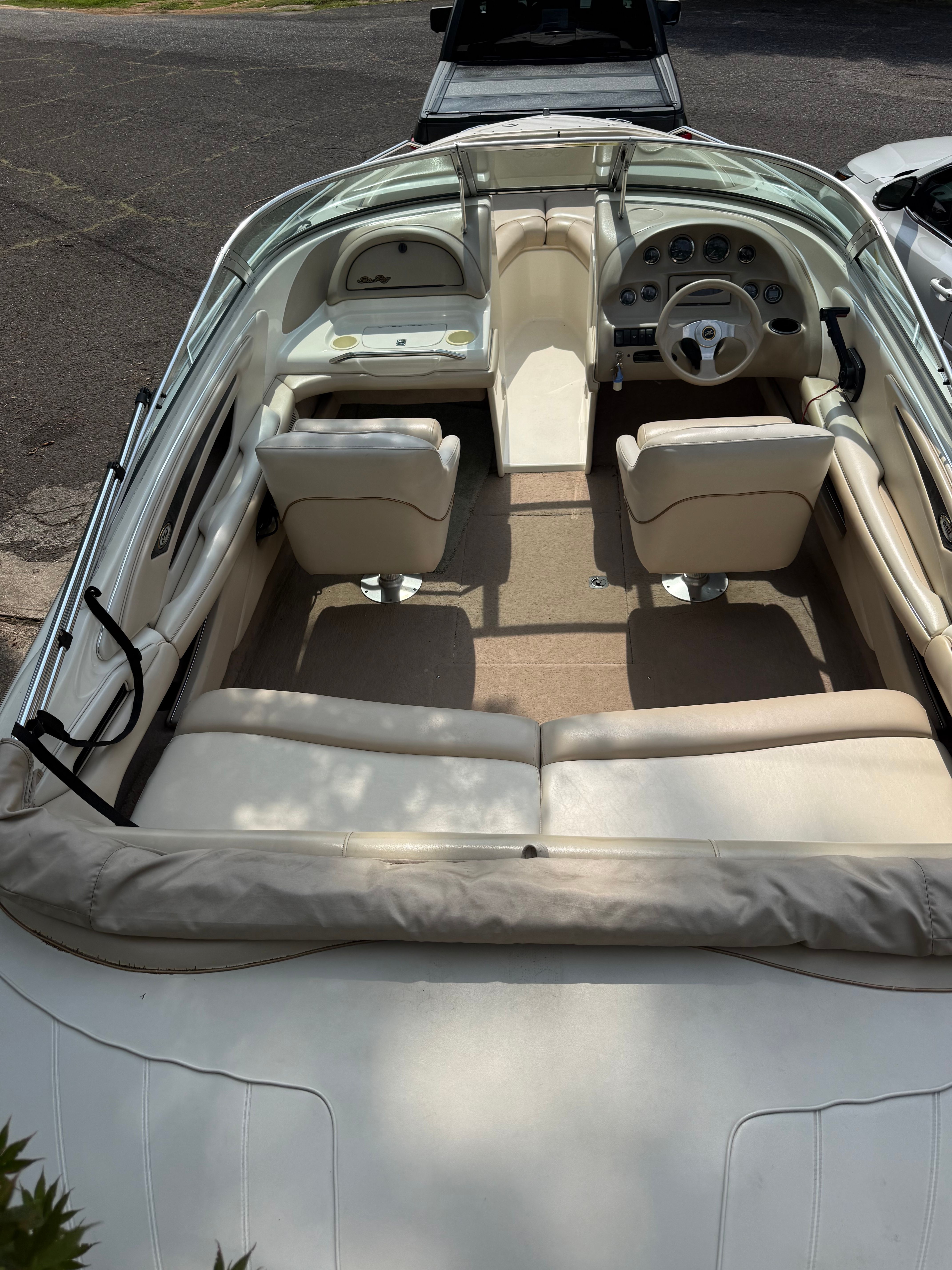Interior view of a 1999 Sea Ray 210 Bow Rider Signature with beige seats and dashboard.