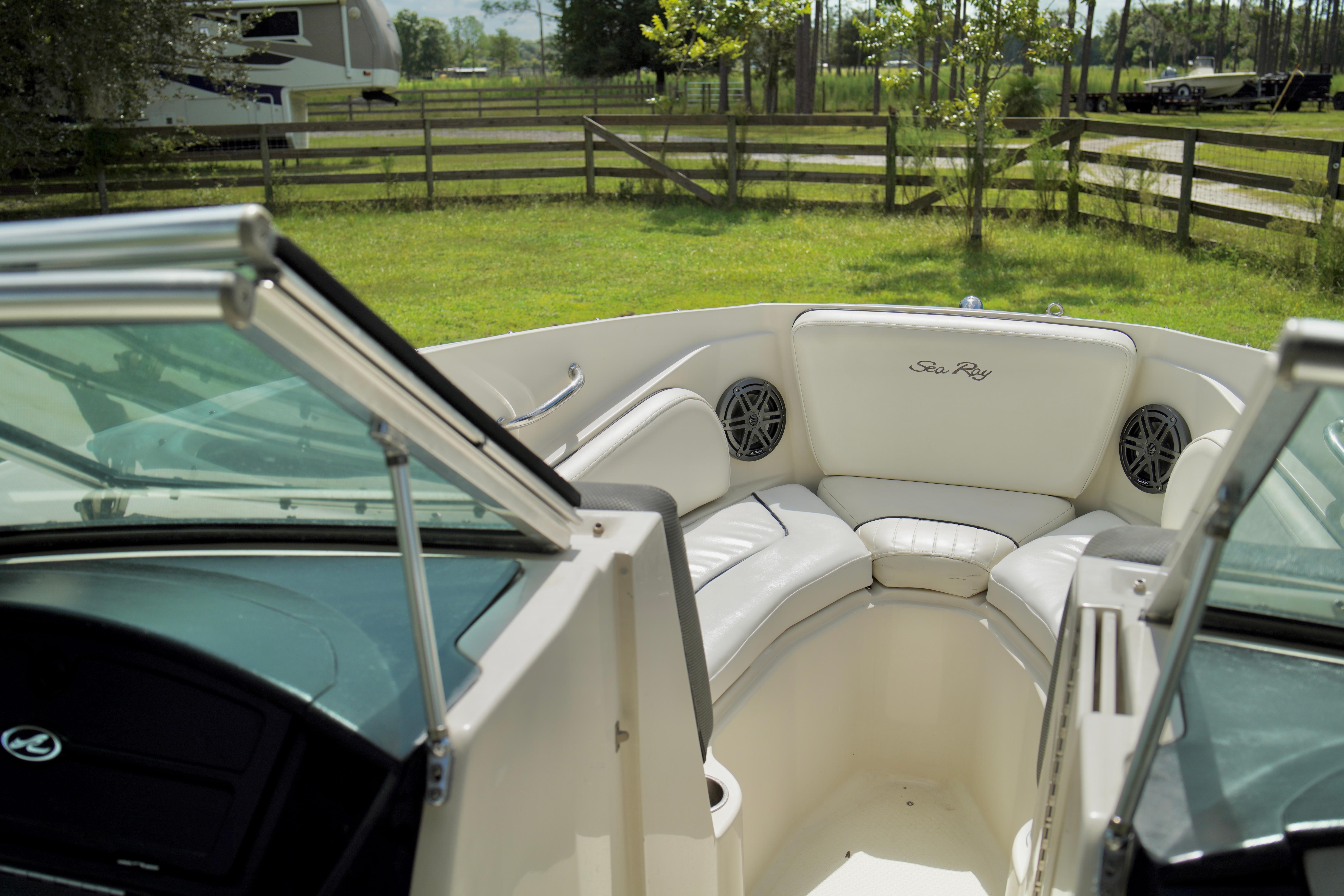 Interior of 2008 Sea Ray 230 Select Fission boat with white seating and open windshield.