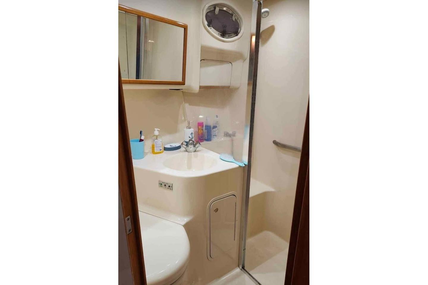 Bathroom interior of 1997 Sea Ray 400 Sedan Bridge yacht, featuring sink and shower.