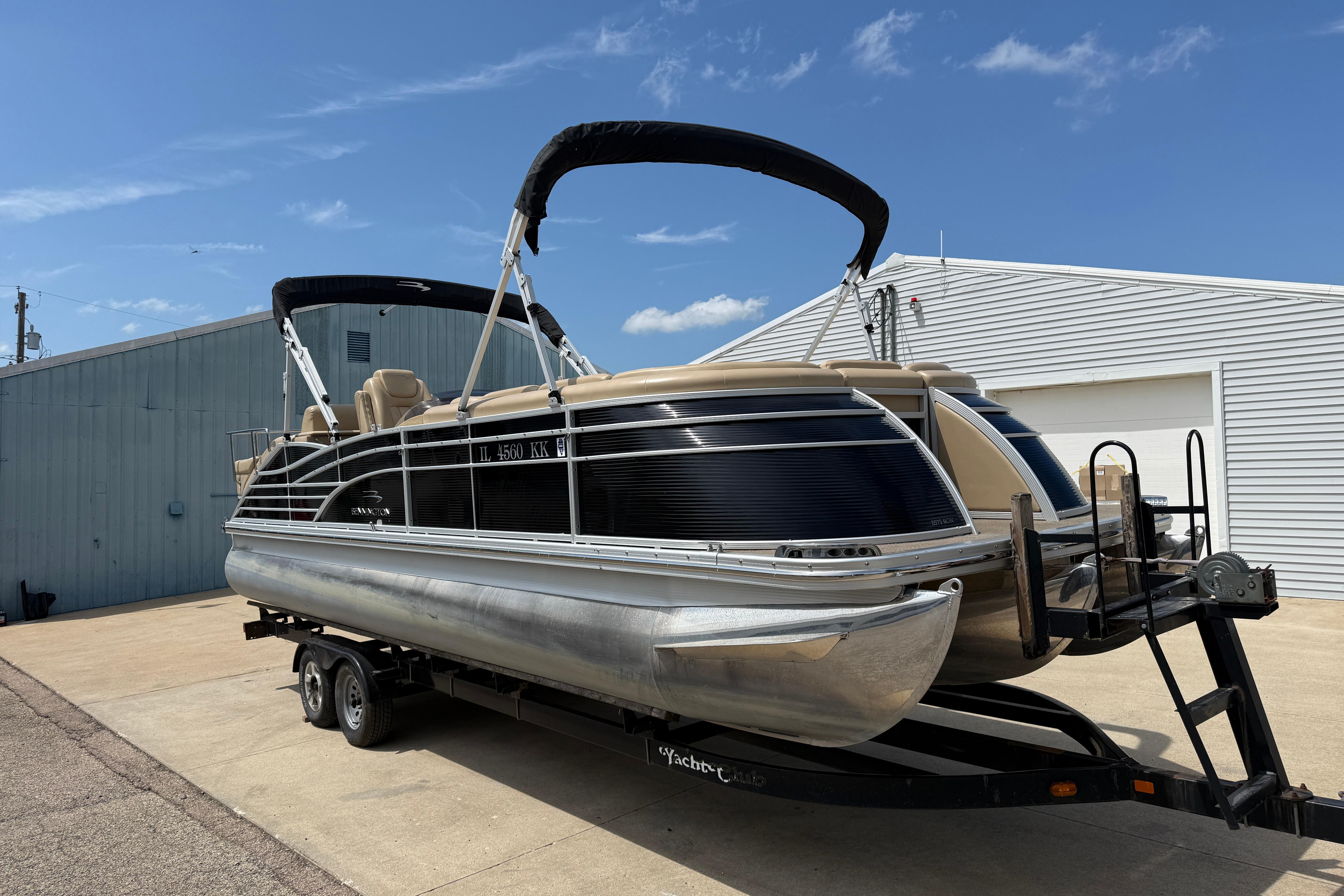 2011 Bennington 2575QCW I/O pontoon boat on trailer, parked outdoors under blue sky.