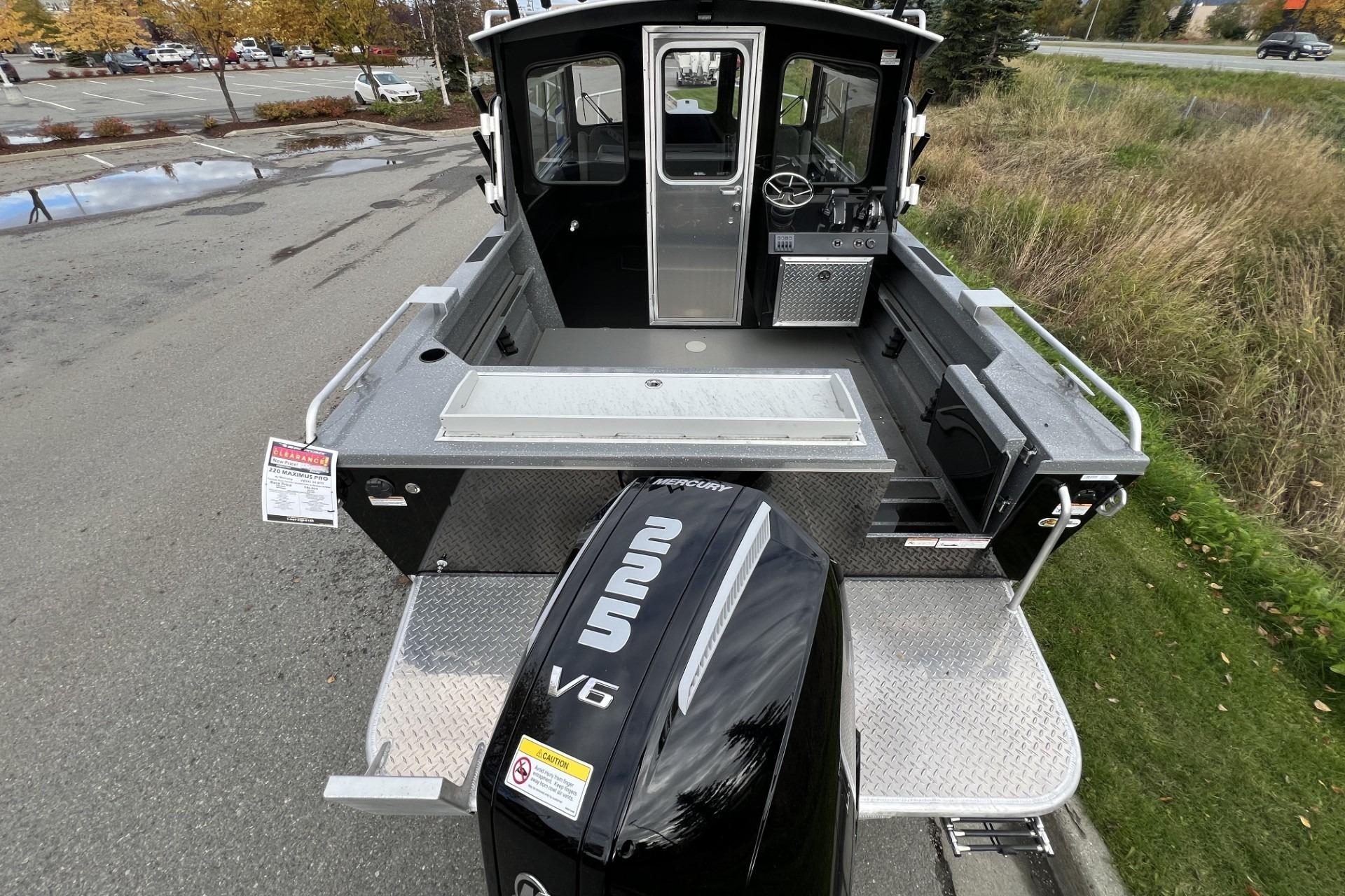 2024 Spartan 220 Maximus boat with Mercury V6 engine, parked on a paved area.