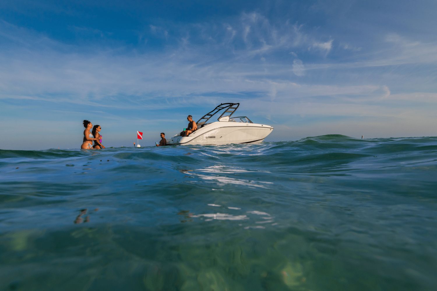 A Yamaha 222SD boat on the water with people swimming in the sea.