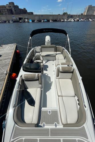 2020 Crownline E 205 XS boat docked at marina, featuring spacious seating and sleek design.