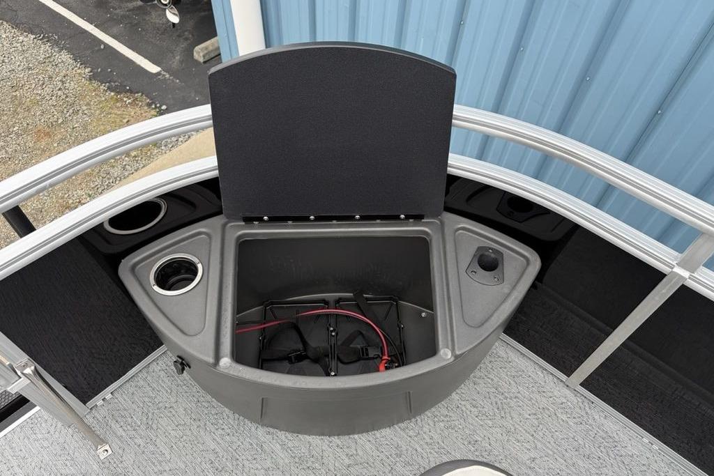 2026 Sun Tracker Fishin' Barge 20 DLX boat with open storage compartment and cup holders.