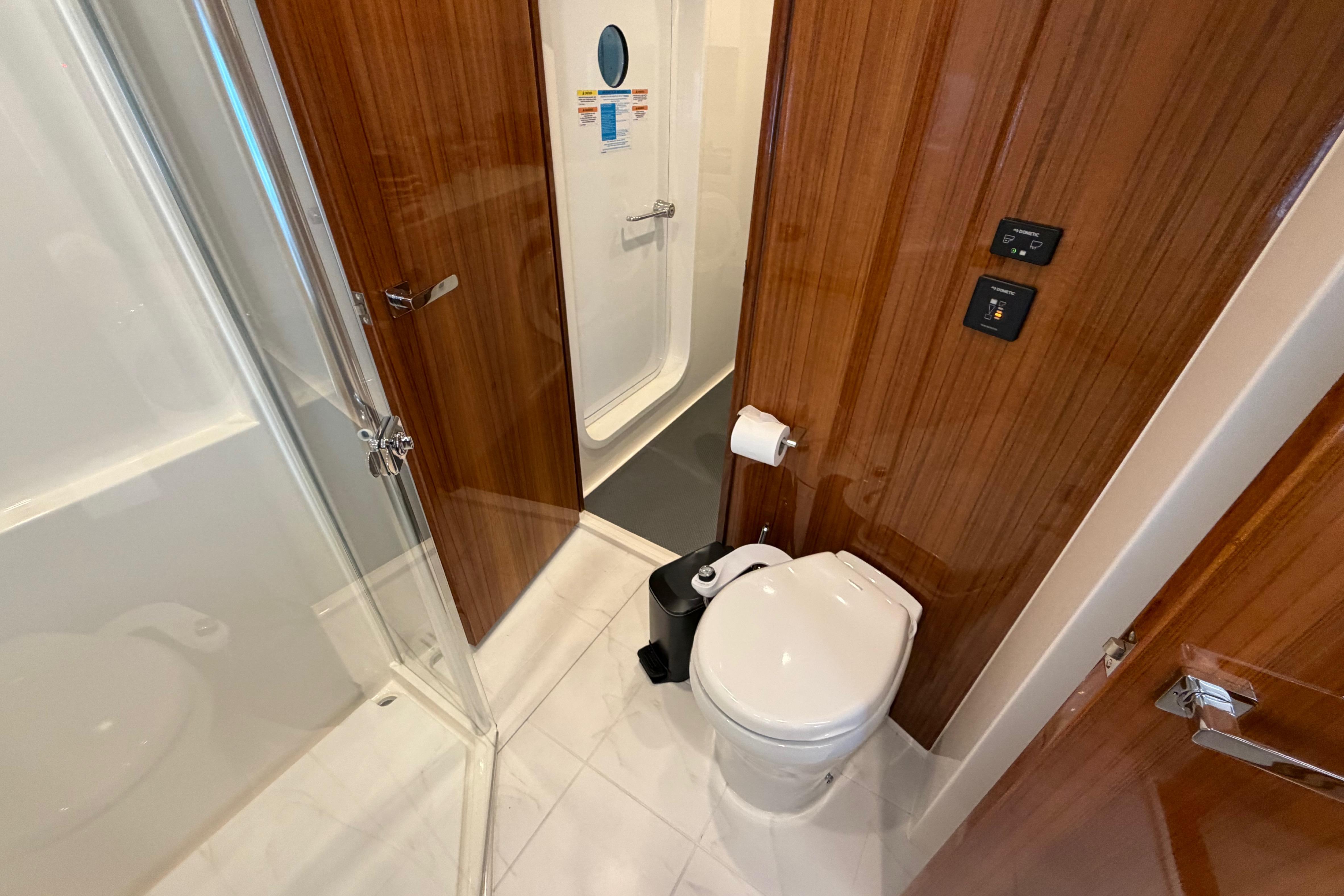 Luxurious bathroom in 2023 Riviera 645 SUV yacht with wooden accents and modern fixtures.