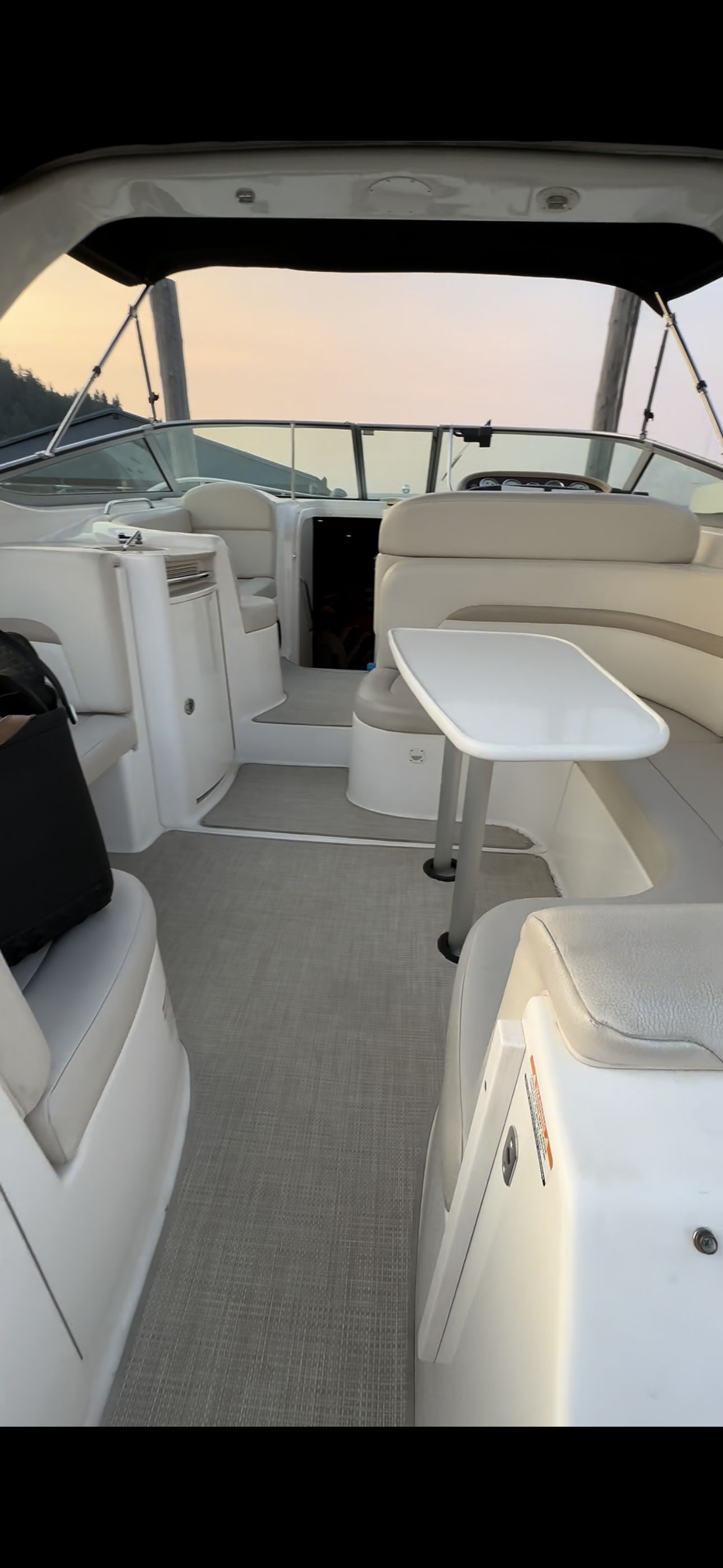 The image shows the cockpit of a 2004 Chaparral Signature 330 with beige seating and a table.