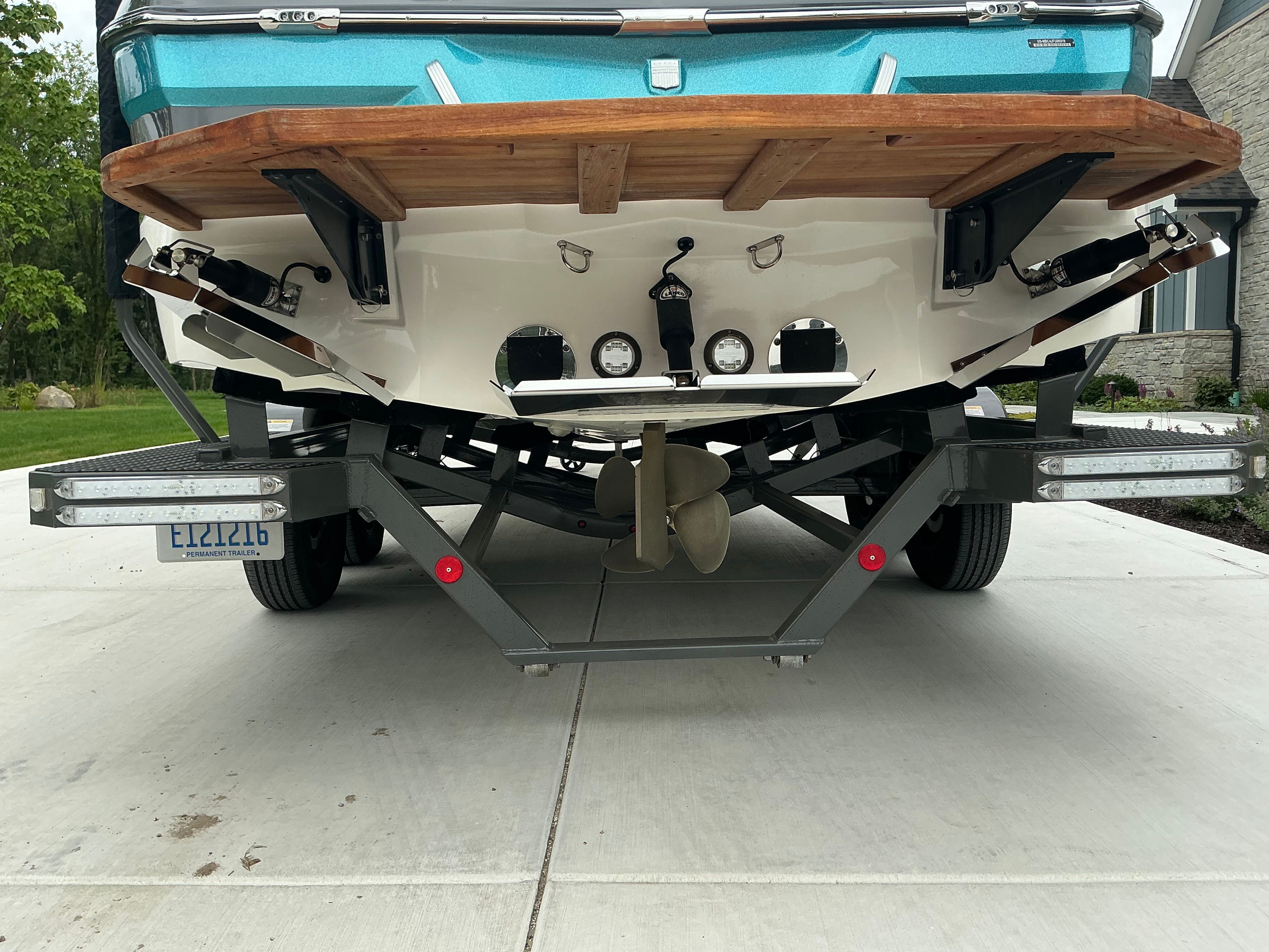 Rear view of a 2019 MasterCraft XT22 on a trailer, showing propeller and platform.