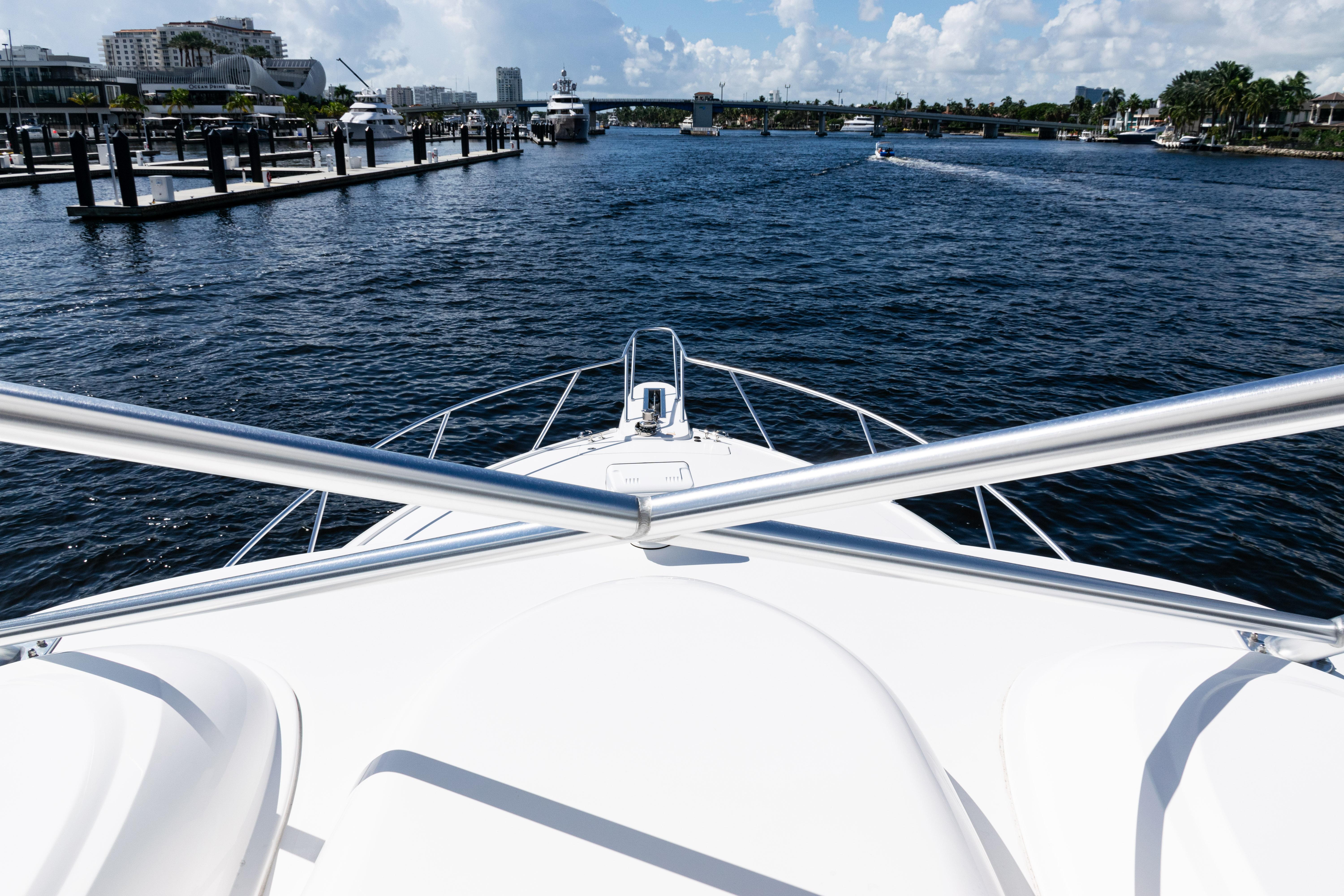 Bow view of 2021 Viking 44 Open yacht navigating a marina.