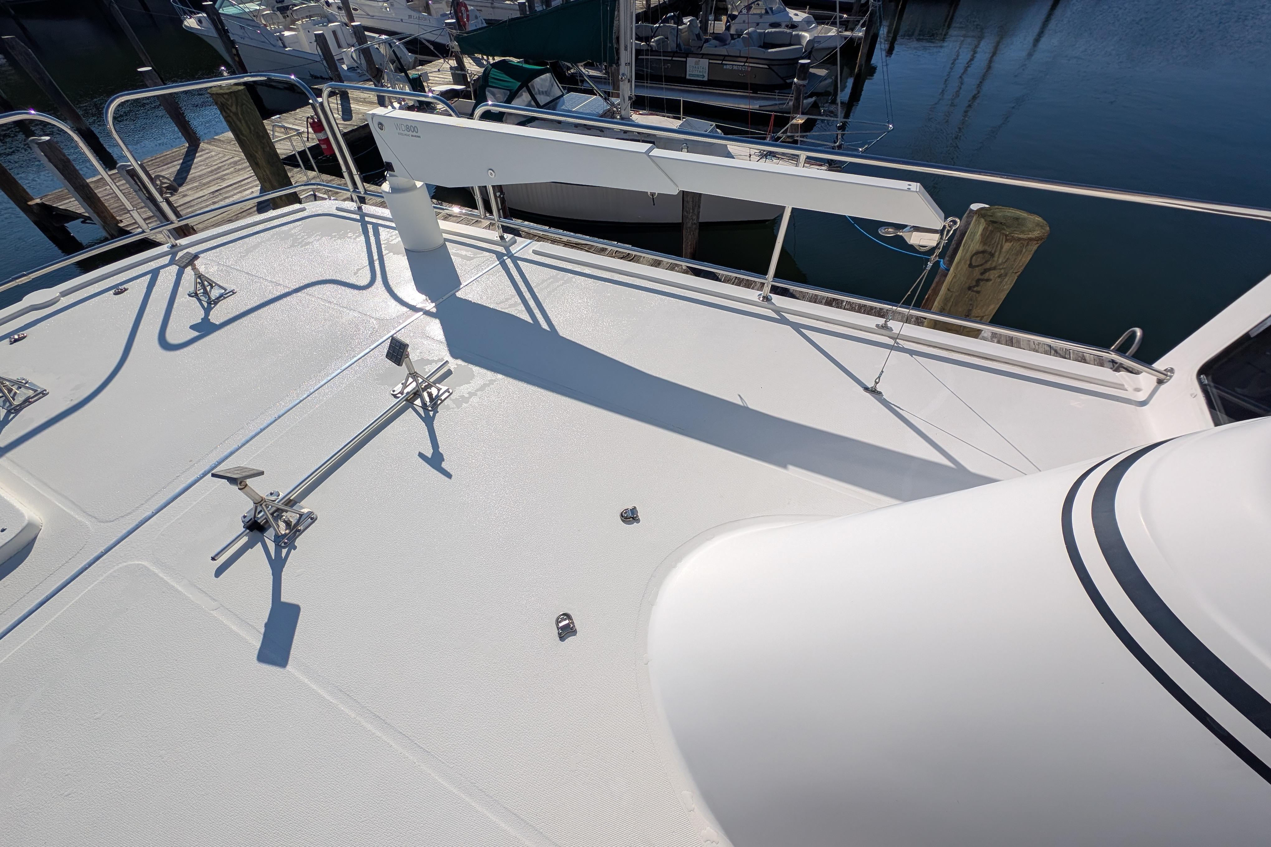 Deck of 2015 American Tug 435 yacht at marina, featuring railings and equipment.