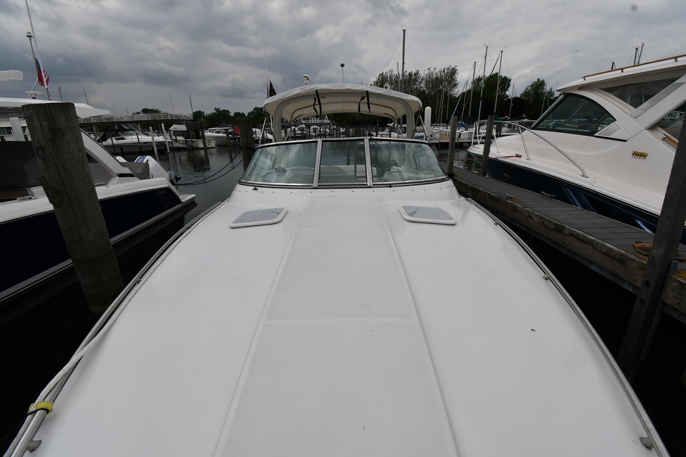 2004 Formula 330 Sun Sport boat docked at marina under cloudy sky.