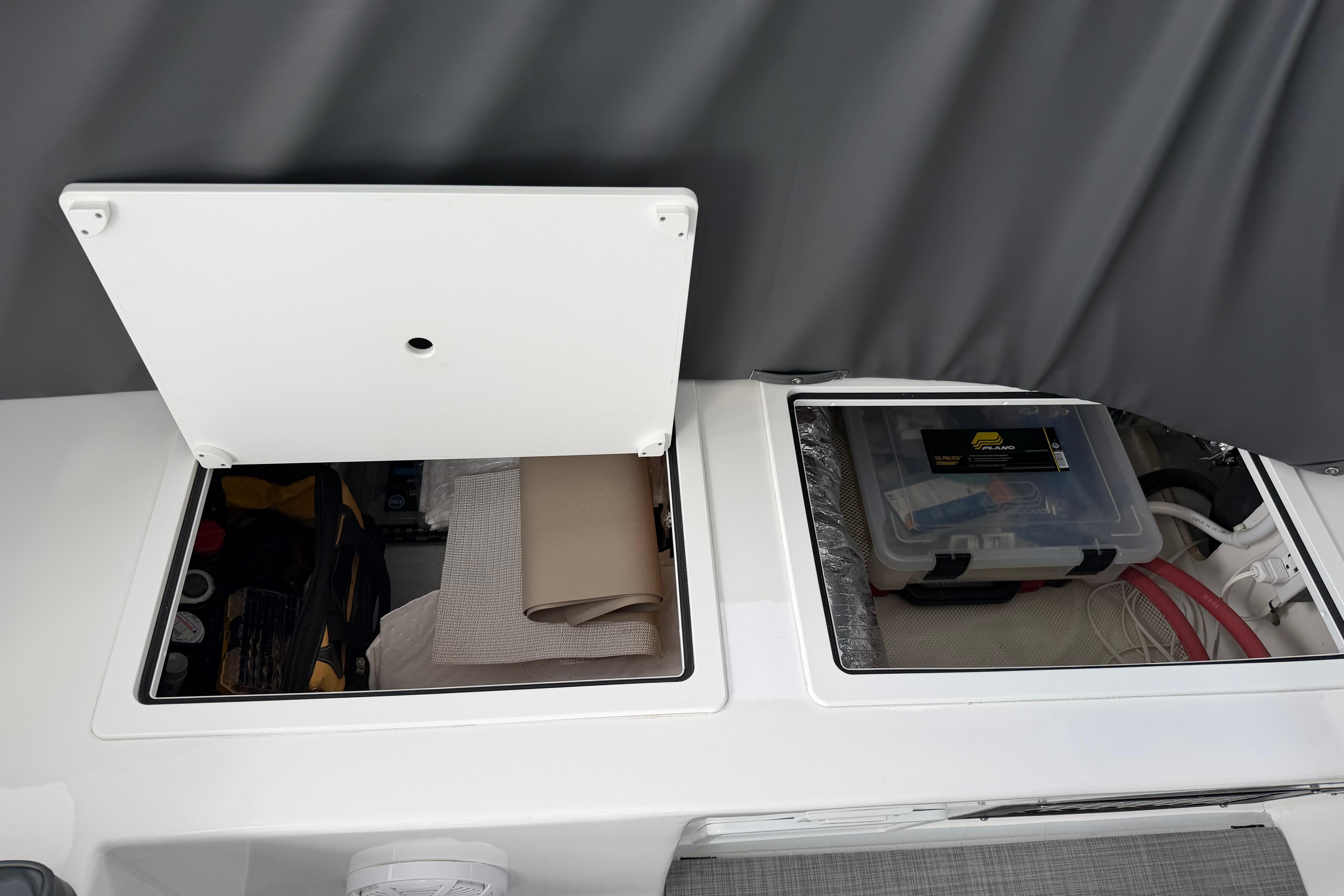 Storage compartments on a 2018 H&H Marine Osmond Beal boat, containing tools and equipment.