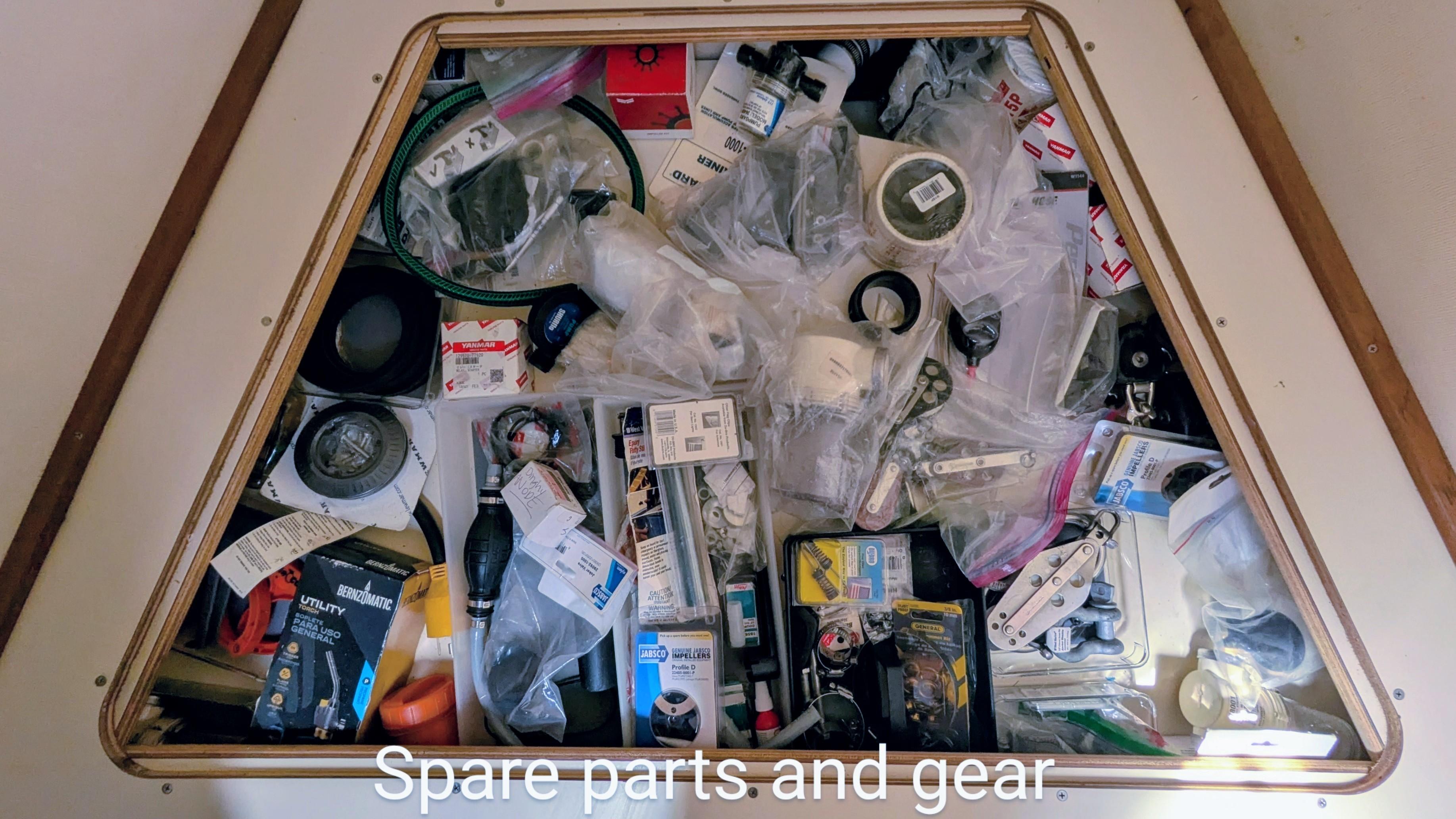 Storage compartment filled with various spare parts and gear for a 2001 Hunter 380.