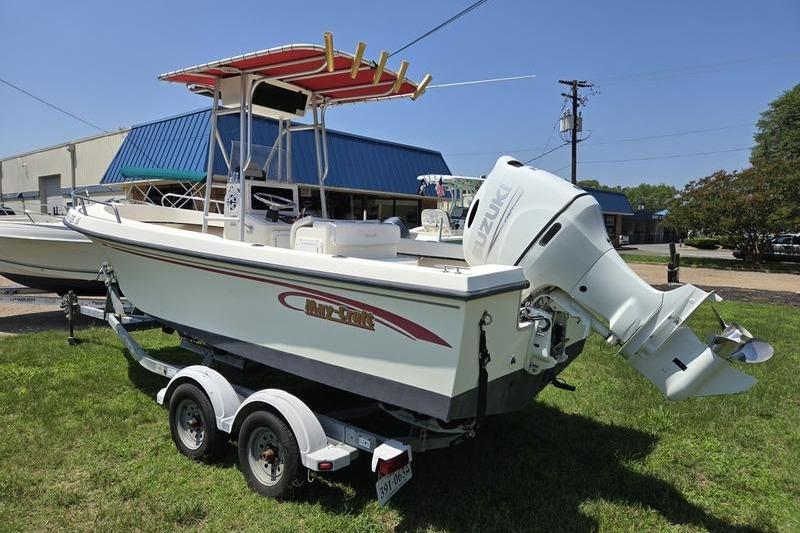 2000 May-Craft 2000CC boat on trailer with Suzuki outboard motor, parked on grass.