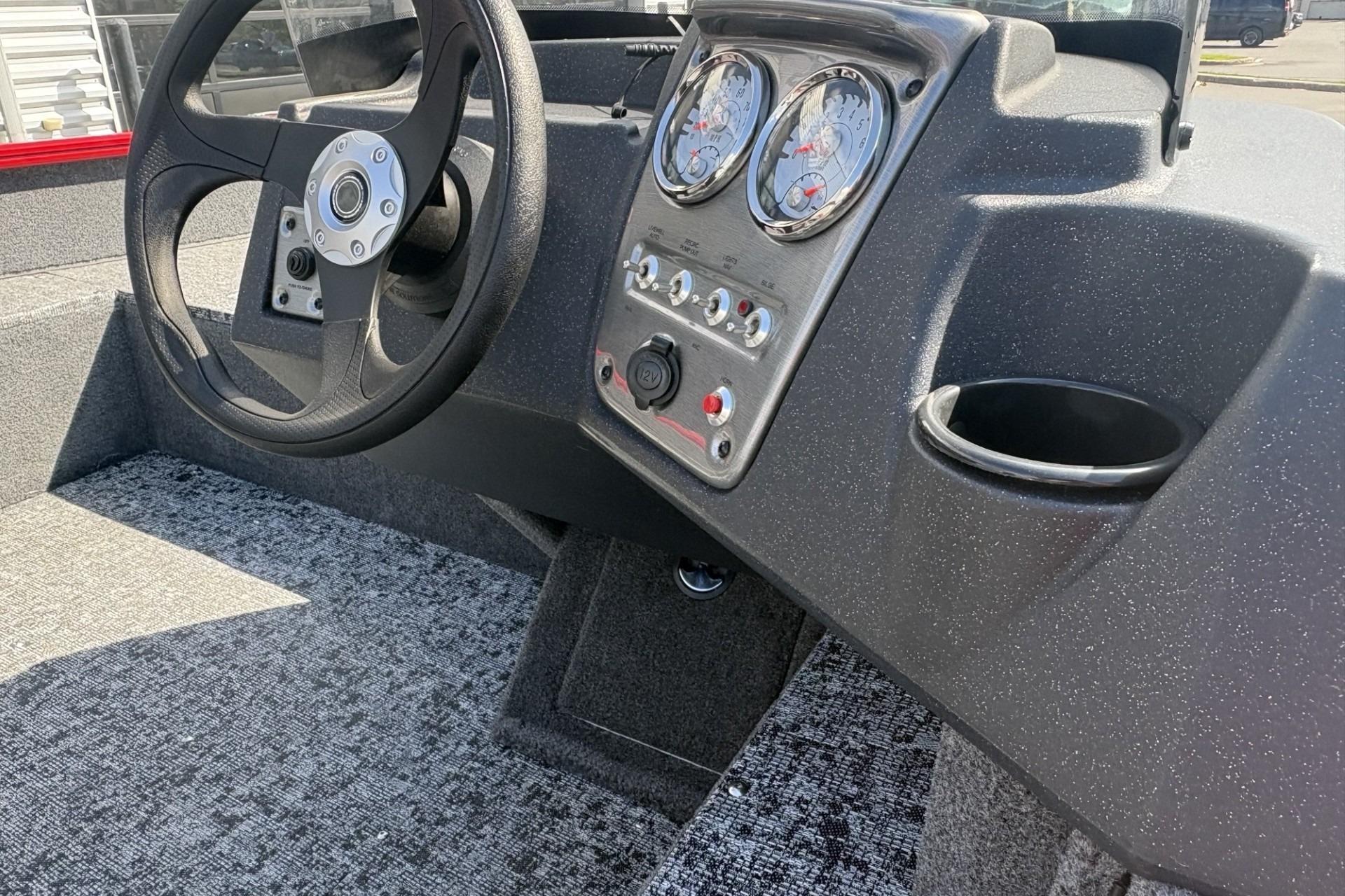 2026 Tracker Pro Guide V-16 SC boat dashboard with steering wheel and gauges.