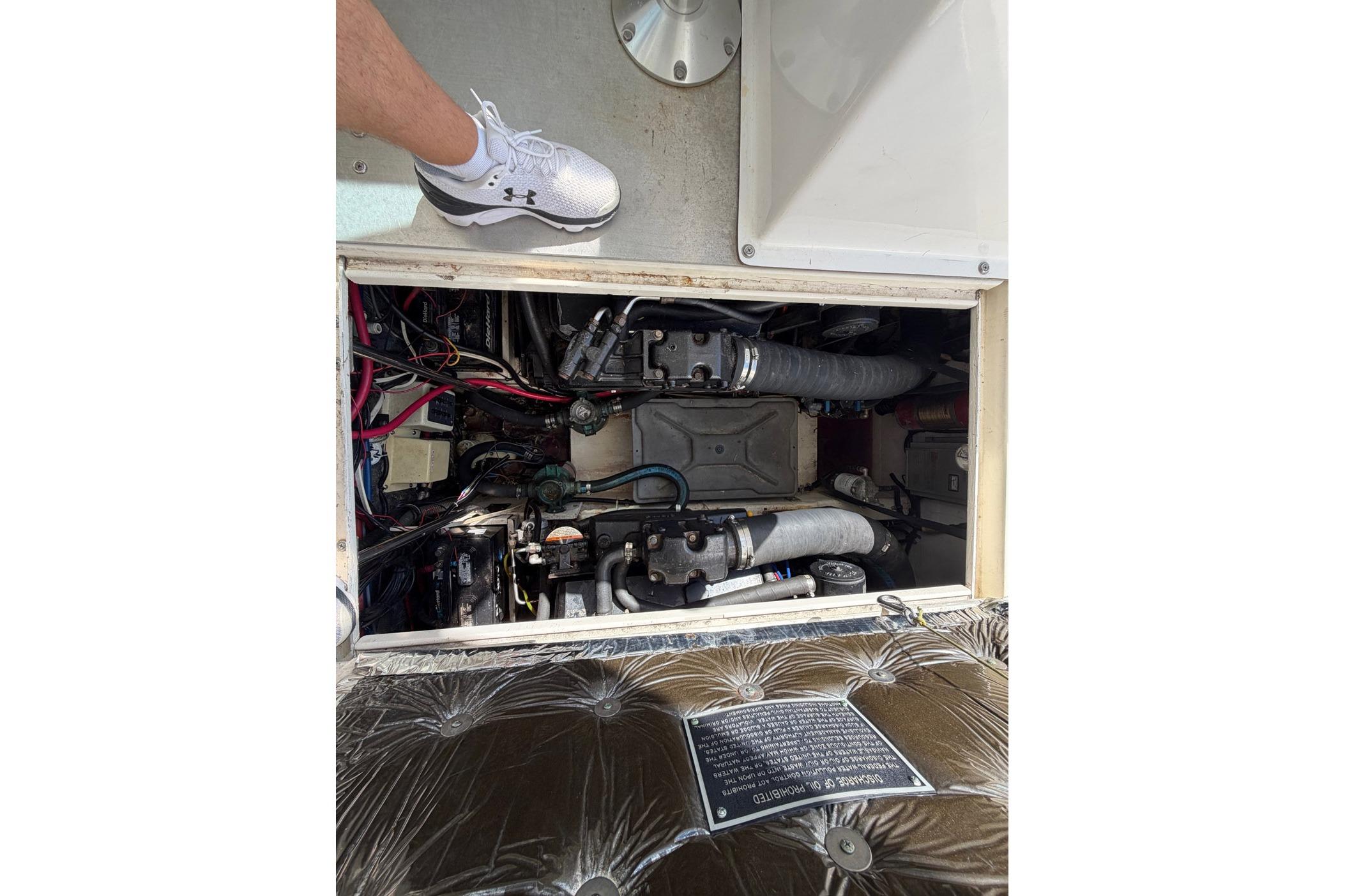 Engine compartment of a 1997 Pursuit 3100 Express boat, showing mechanical components.