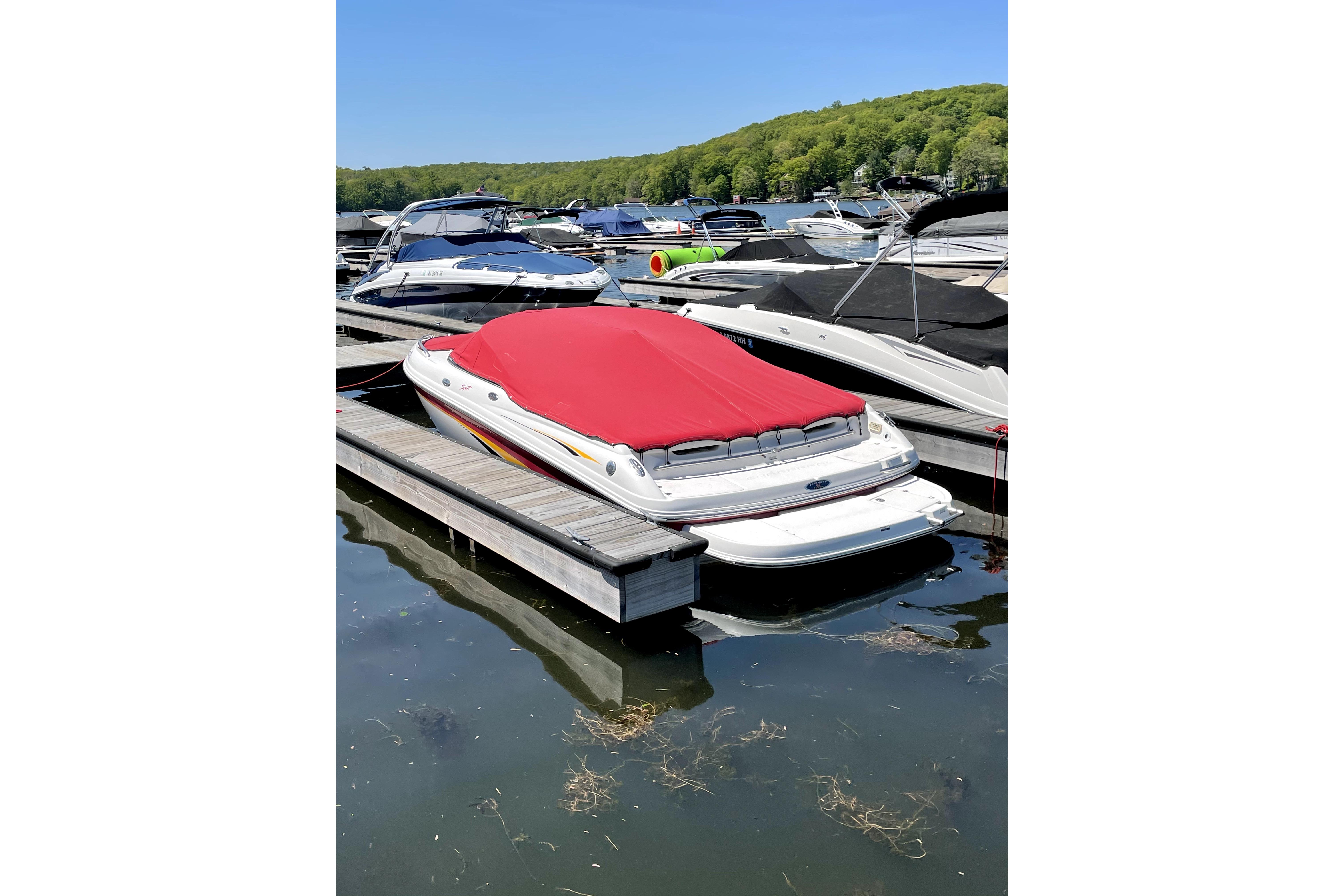 2003 Chaparral 200 SSi boat with red cover docked at marina.