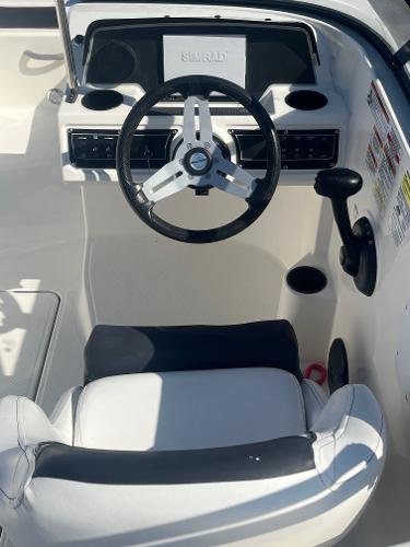 2021 Bayliner DX 2200 boat cockpit with steering wheel and control panel.