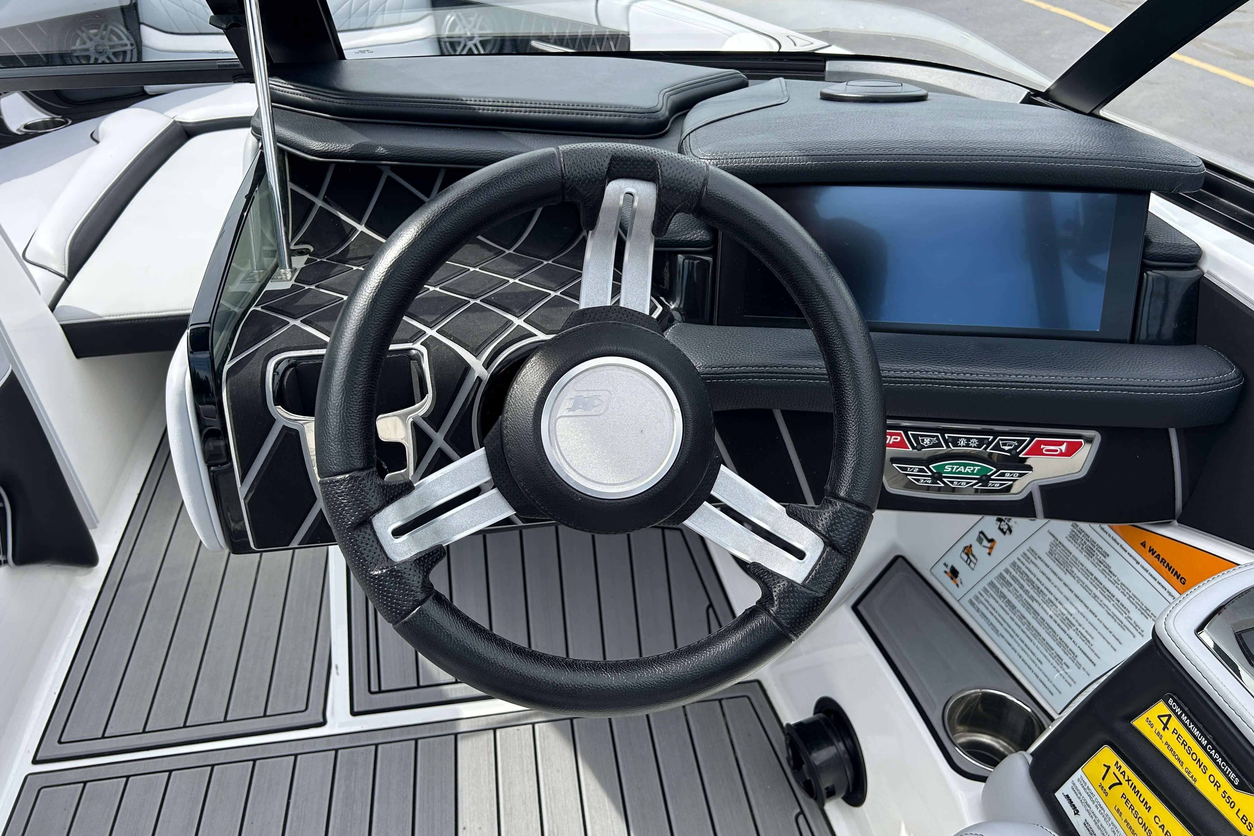 2021 Nautique Super Air Nautique GS24 dashboard with steering wheel and touchscreen display.