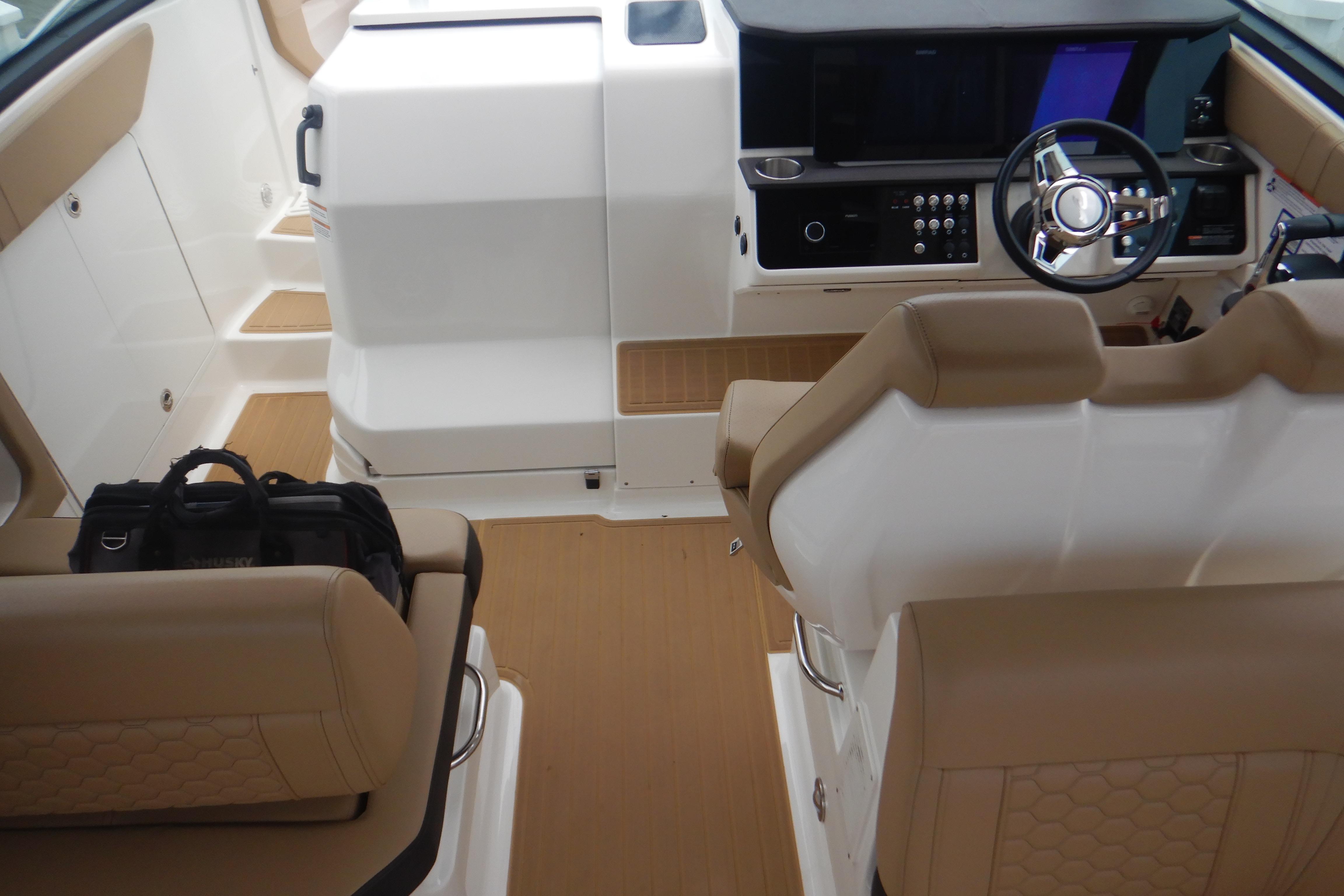2023 Sea Ray Sundancer 320 cockpit with beige seating and modern helm controls.