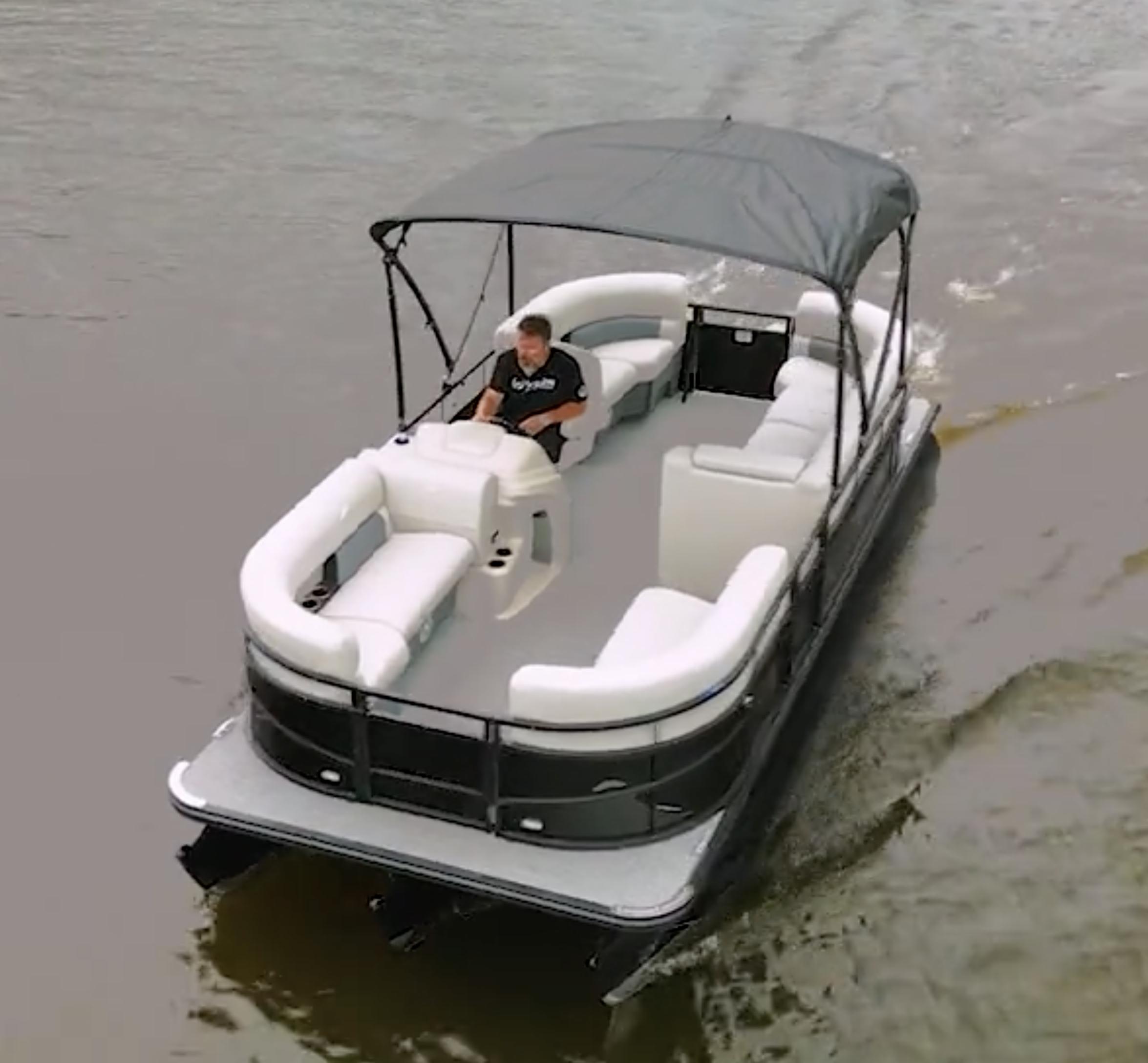 2024 Vision Marine Technologies WX Tritoon cruising on water with canopy and seating.