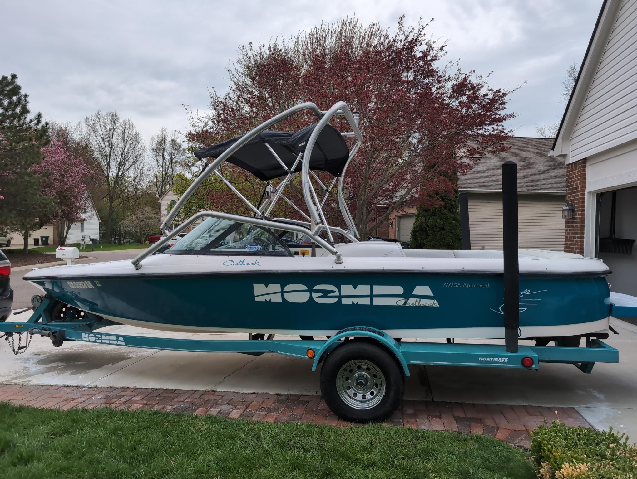 A blue 2000 Moomba Ouback LS on a trailer in a driveway.