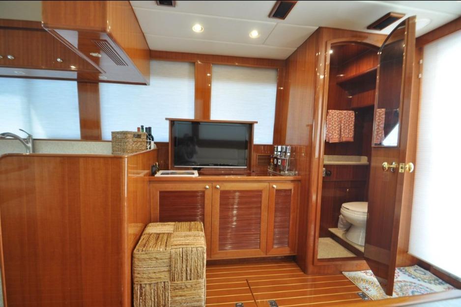 Luxurious 2004 Hampton F/B Cruiser interior with wood finish, TV, and bathroom.