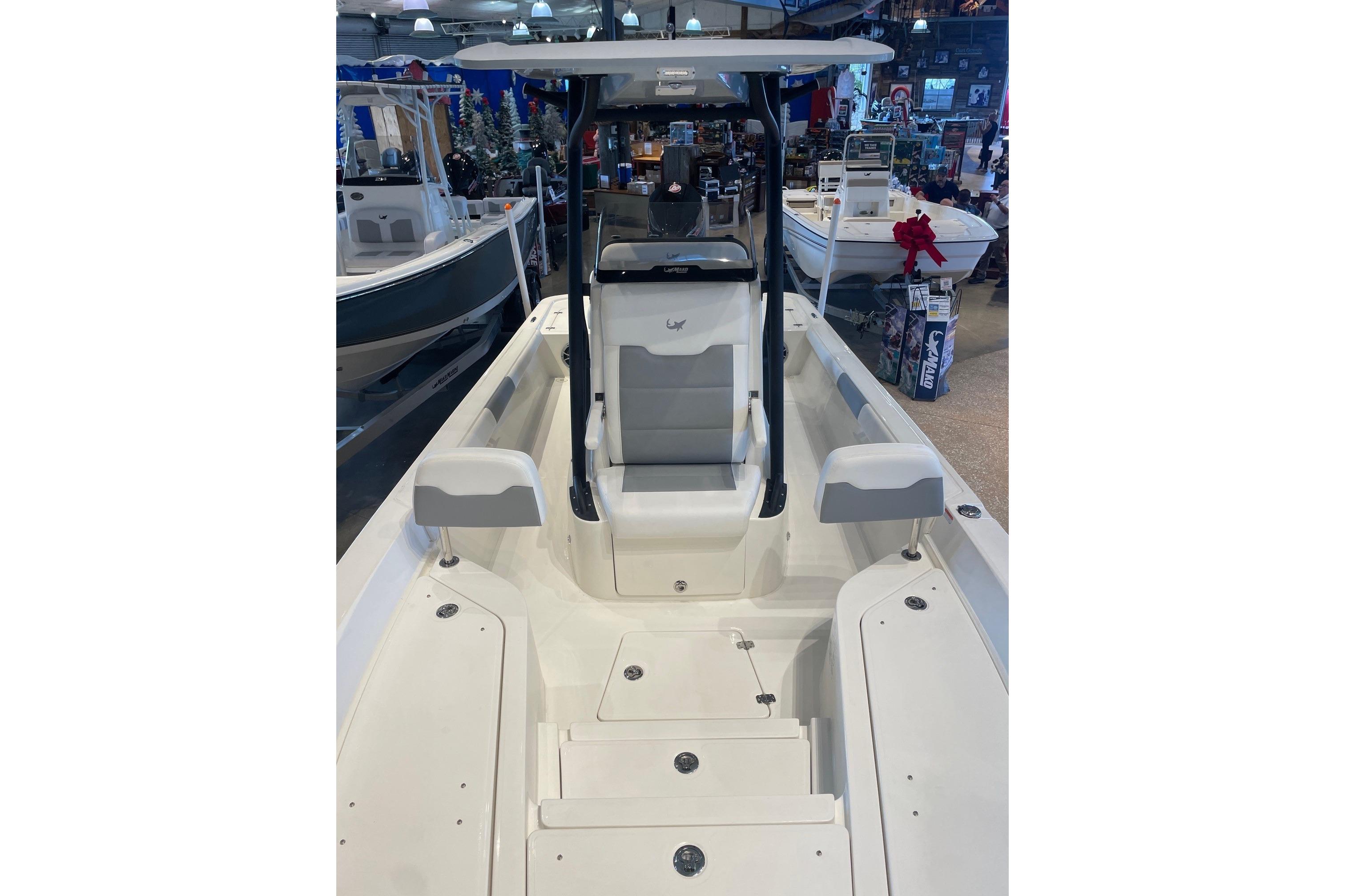 2026 Mako 24 APEX boat interior with seating and storage, displayed indoors.
