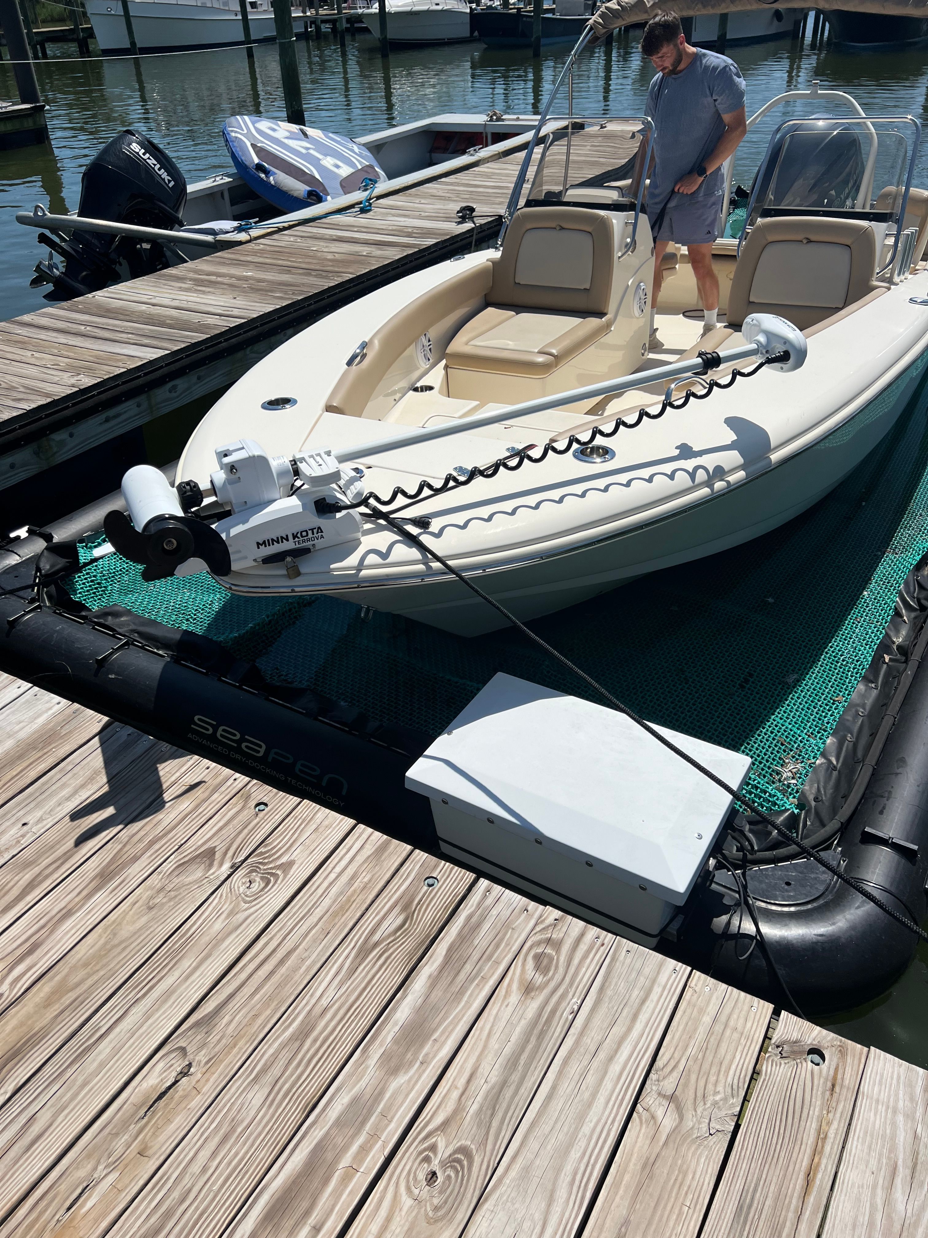 A 2021 Scout 195 Sport Dorado is docked. A man is standing on board.