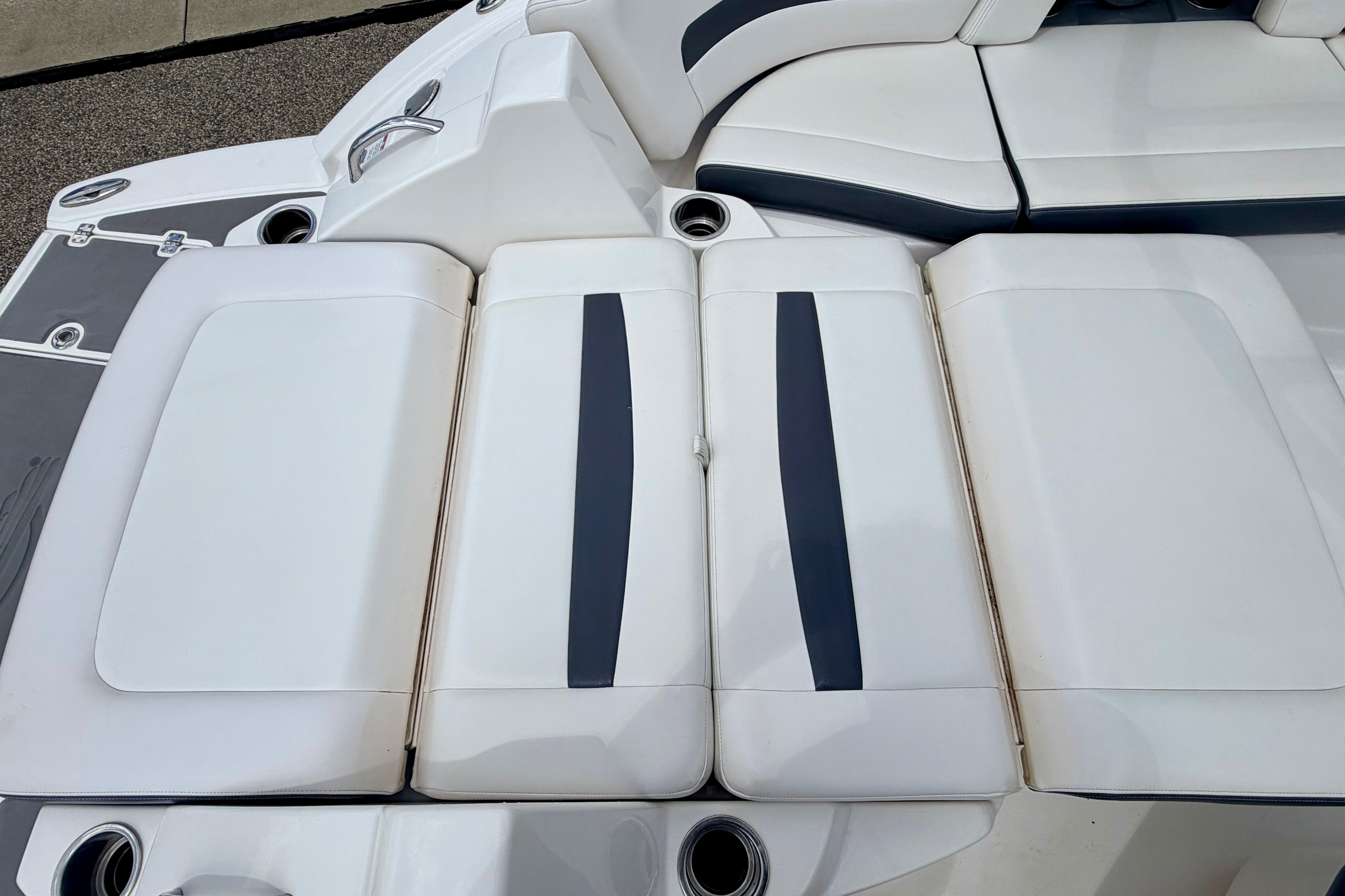 2015 Chaparral Sunesta 264 boat seating area with white and navy upholstery.