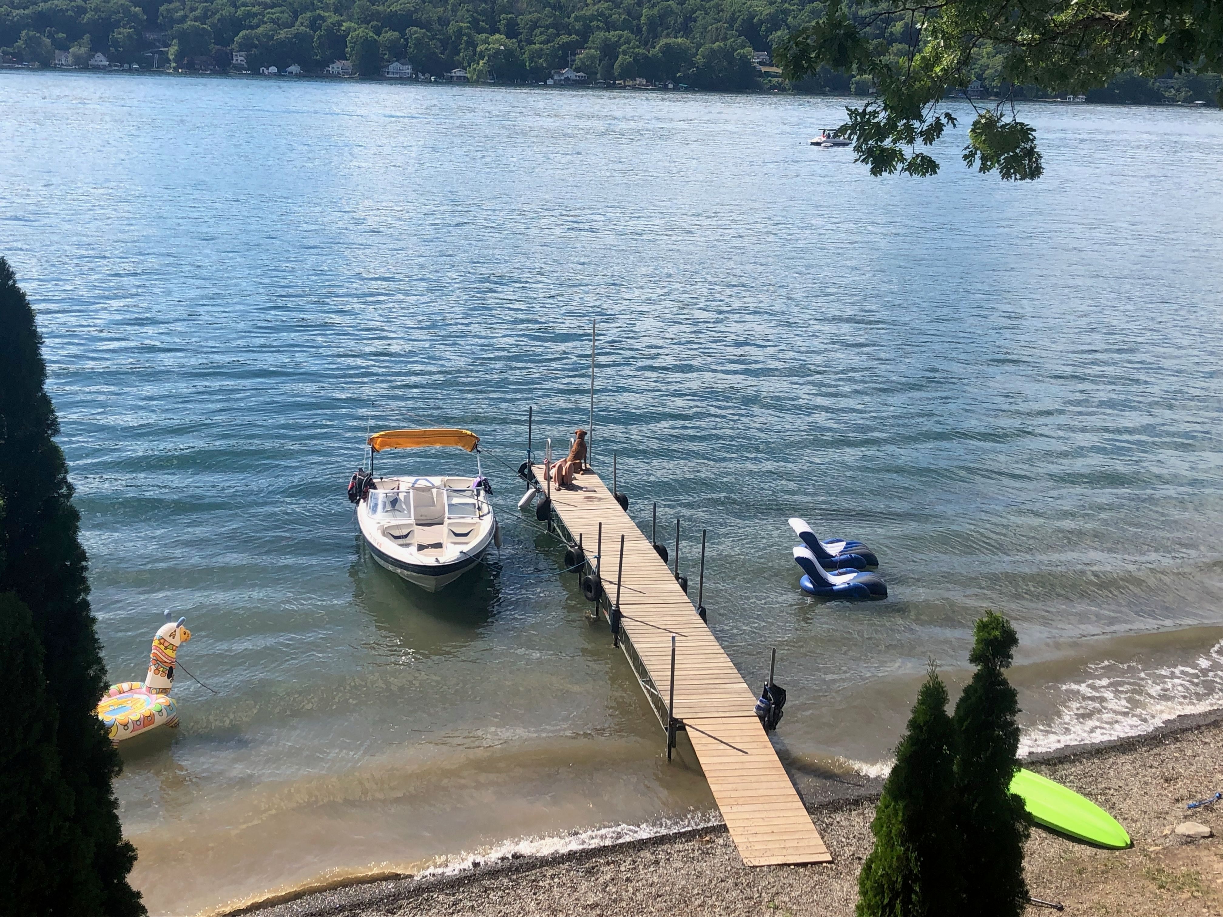 2005 Bayliner 205BR docked with people swimming nearby.