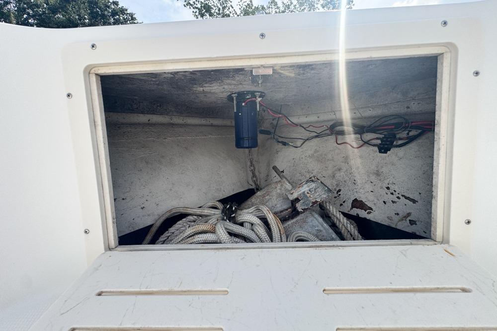Open storage compartment on 2018 Mako 284 Center Console boat with ropes and anchor.