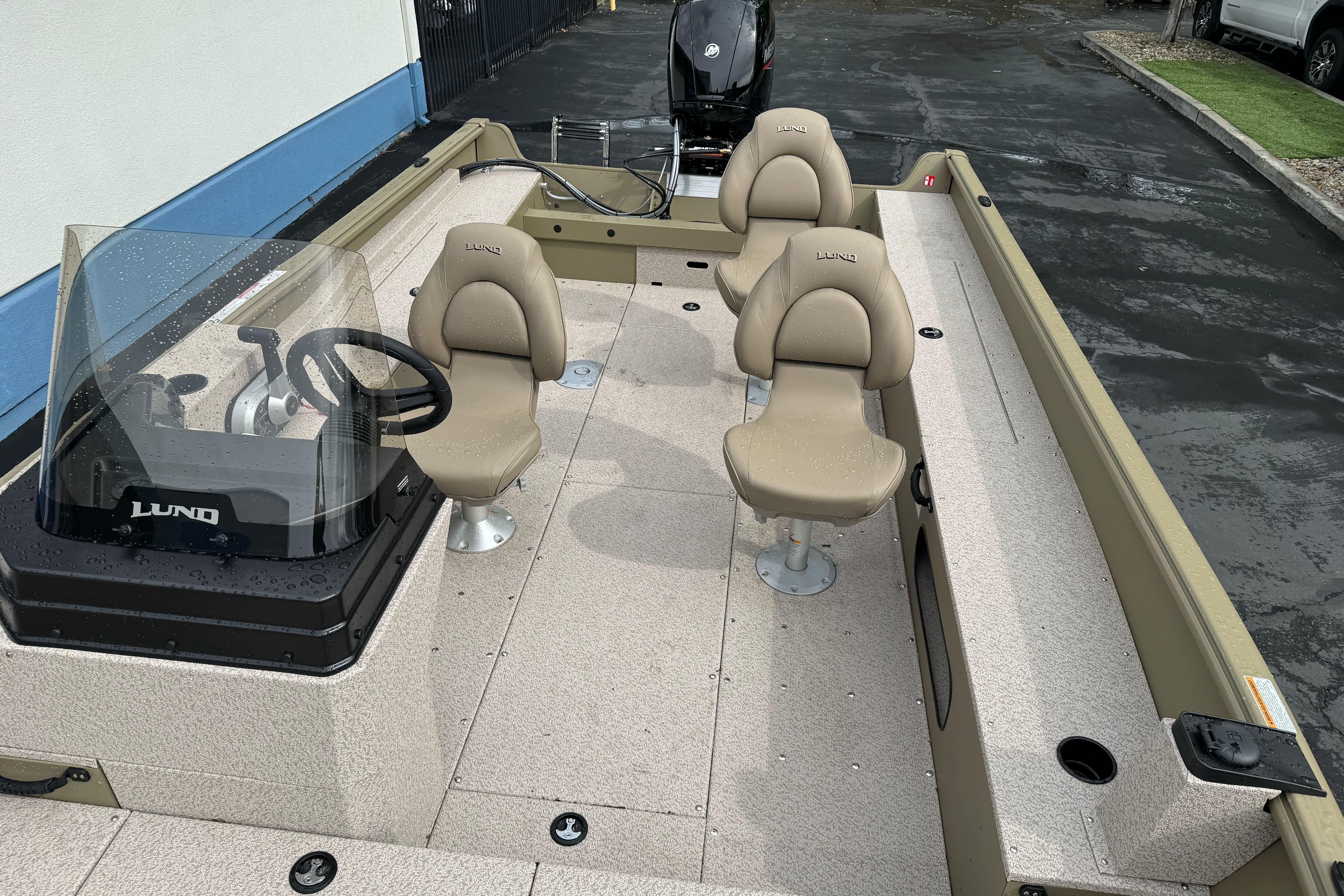 2026 Lund 2075 Alaskan SS boat interior with beige seating and steering console.