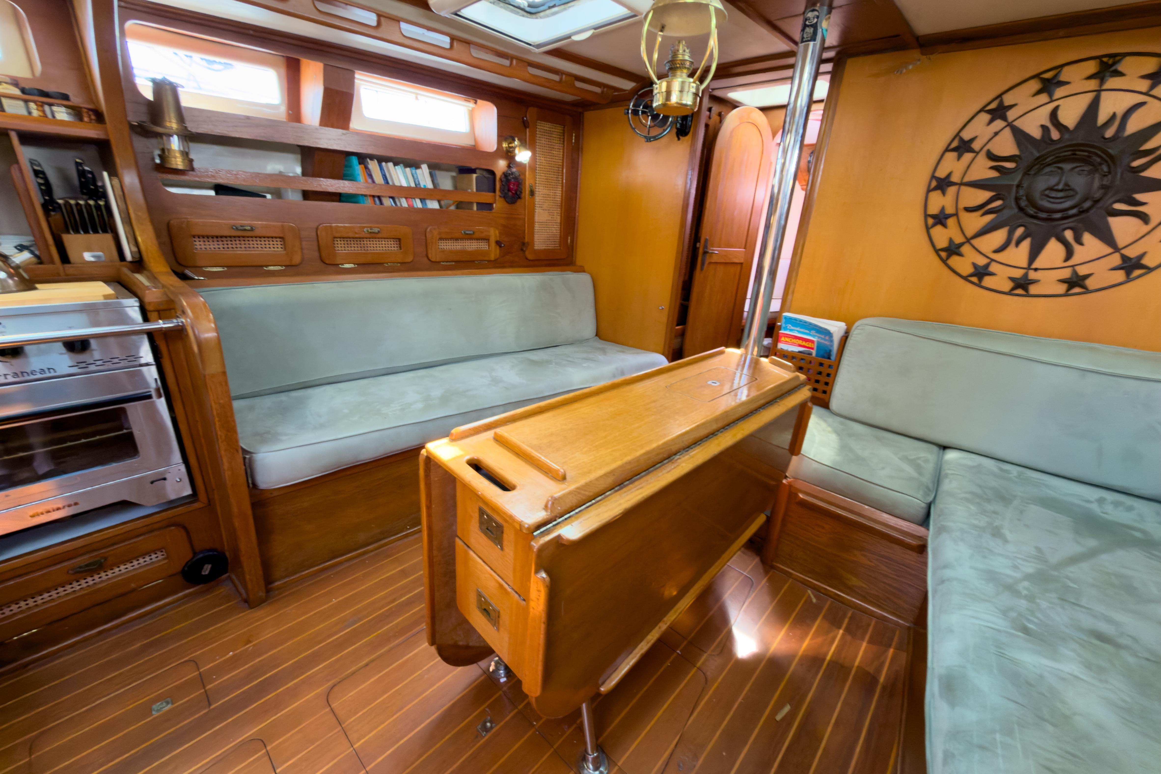 Interior of 1983 Corbin 39 sailboat with wood paneling and cozy seating area.