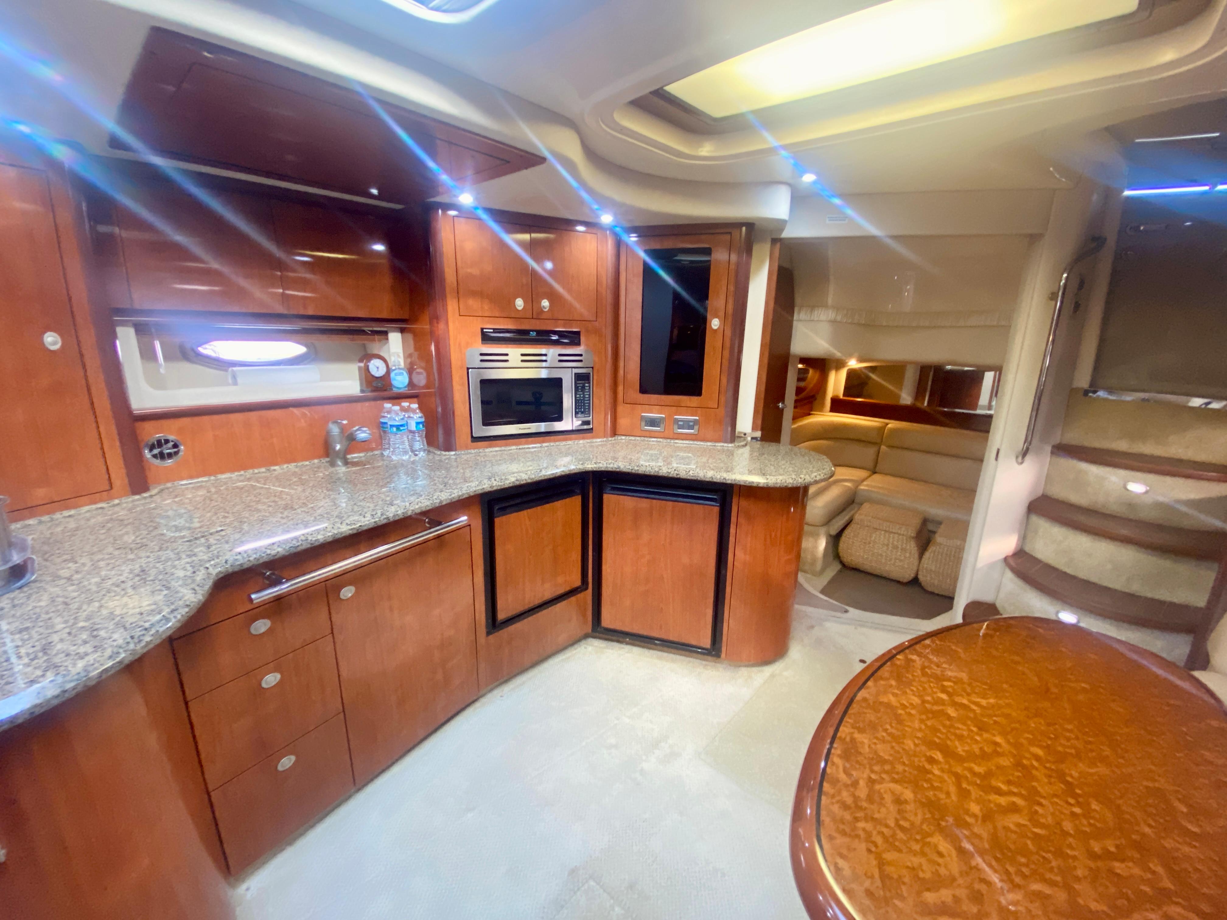 2005 Sea Ray 420 Sundancer yacht interior with modern kitchen and cozy seating area.
