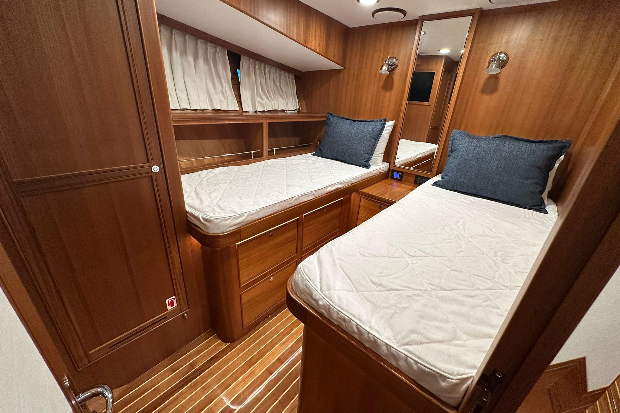 Luxurious twin cabin in 2023 Marlow Explorer 66E-CB yacht with wooden interior.
