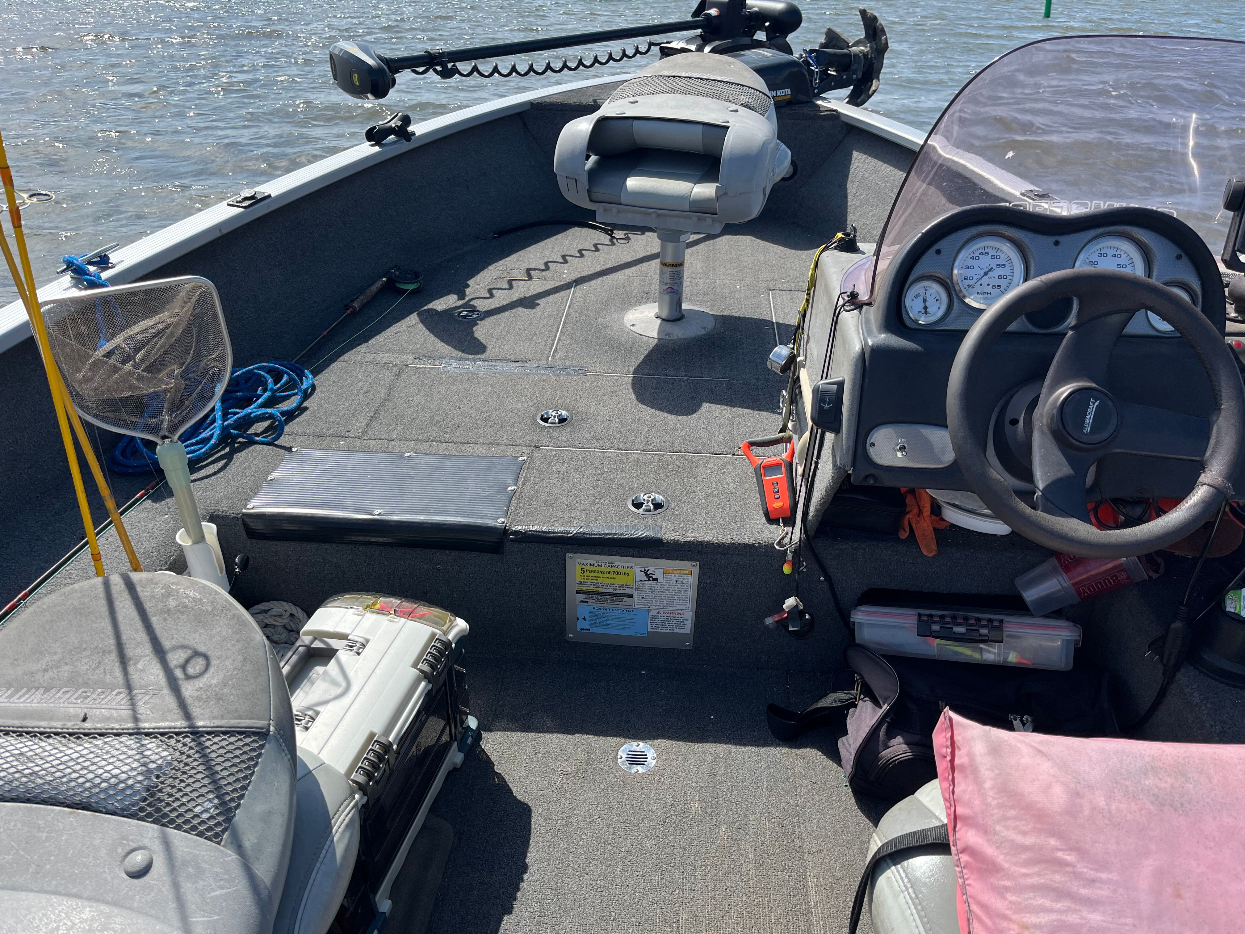Interior view of an Alumacraft Navigator 175CS boat with steering console and seating.