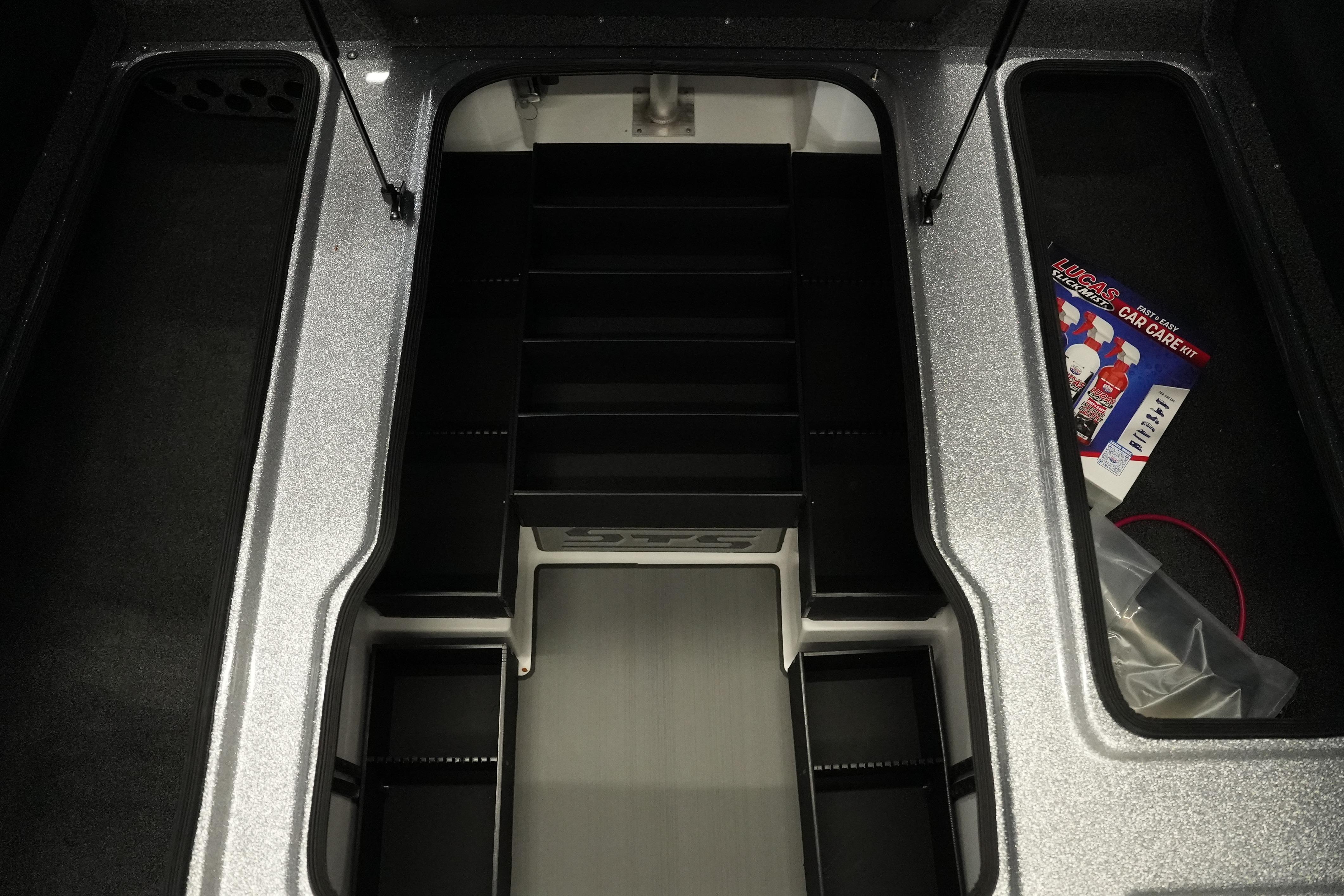 Interior storage compartment of 2026 Bass Cat Lynx STS boat with car care kit.