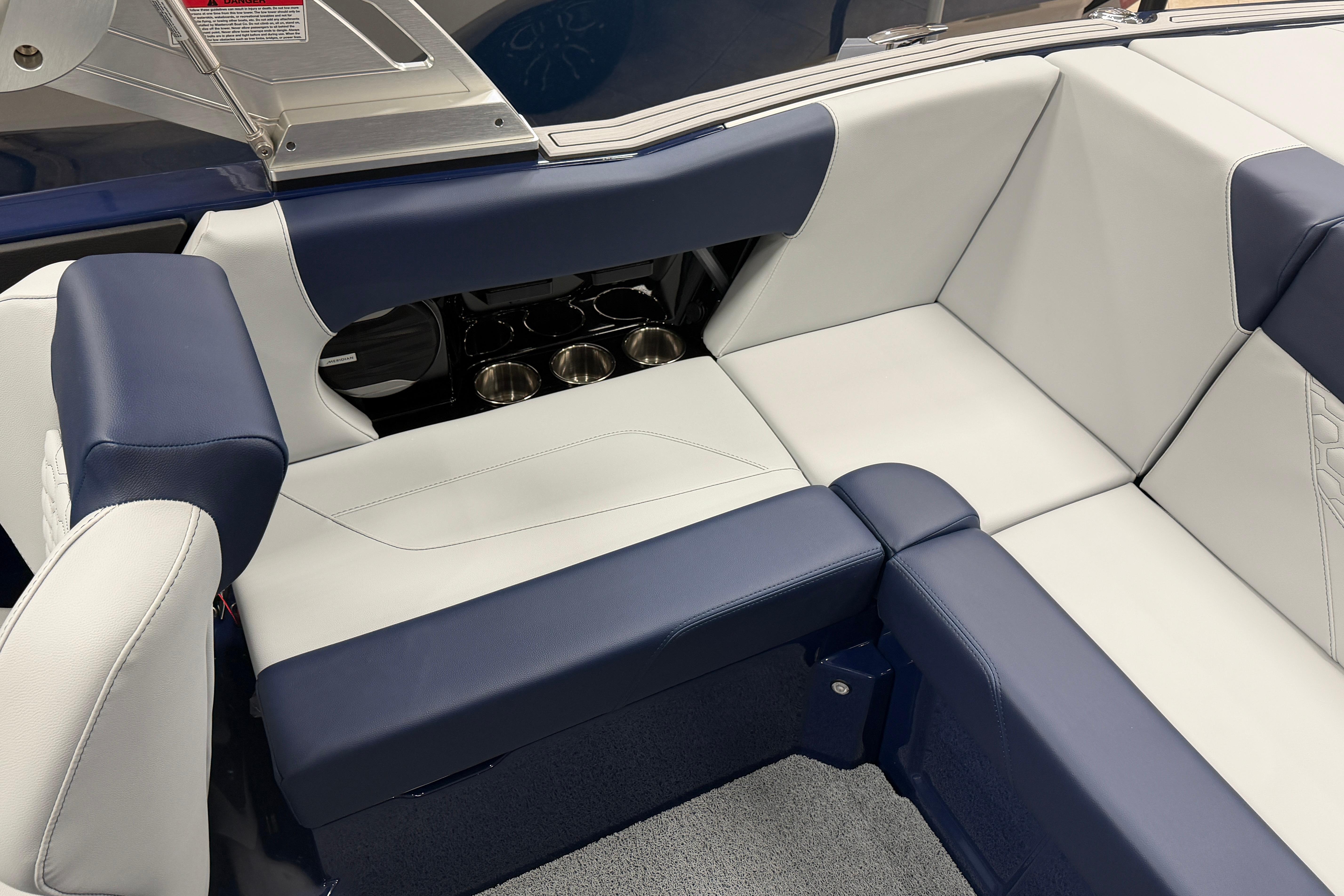 2026 MasterCraft NXT20 boat interior with blue and white seating and cup holders.