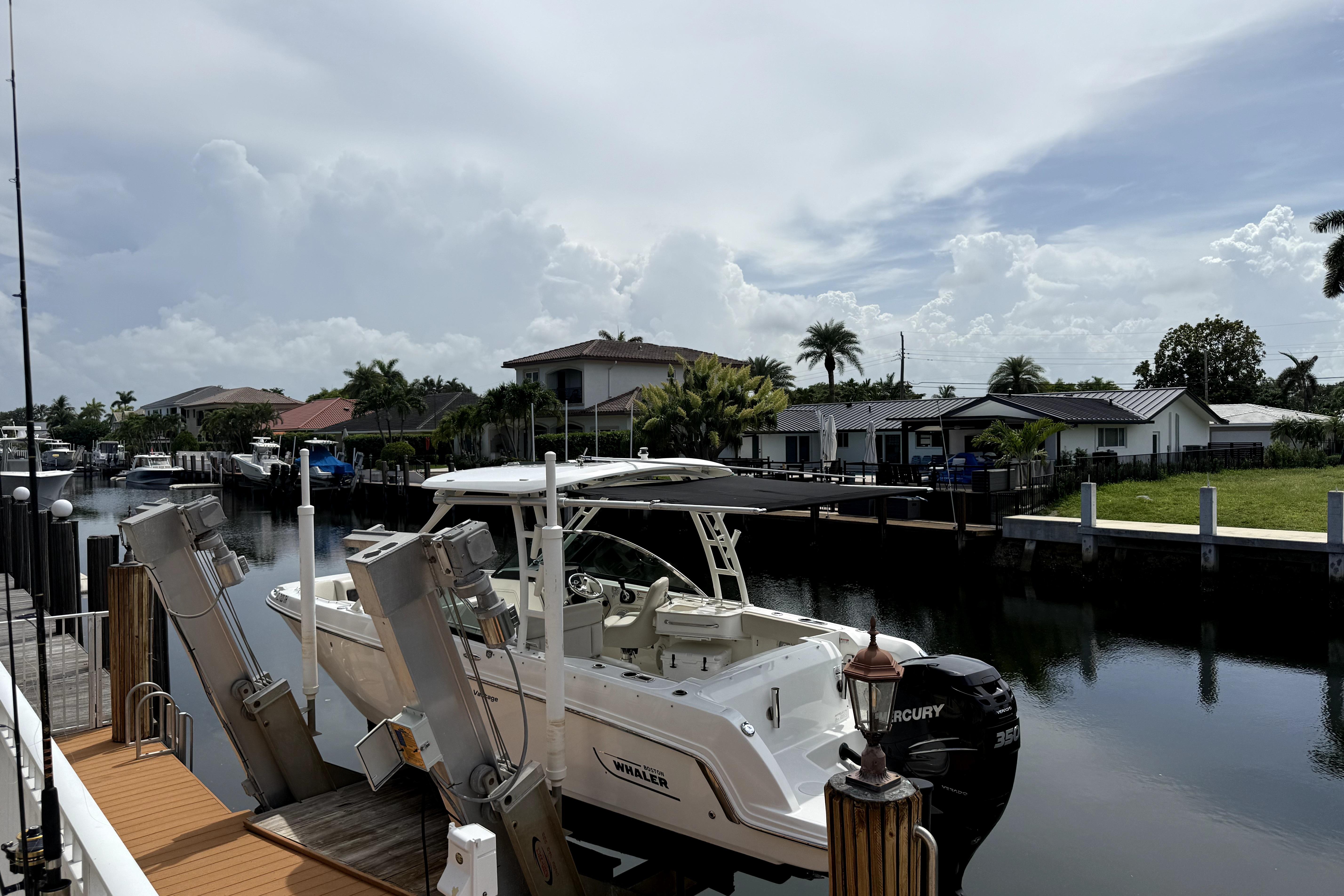 2018 Boston Whaler 230 Vantage docked in a scenic residential canal setting.