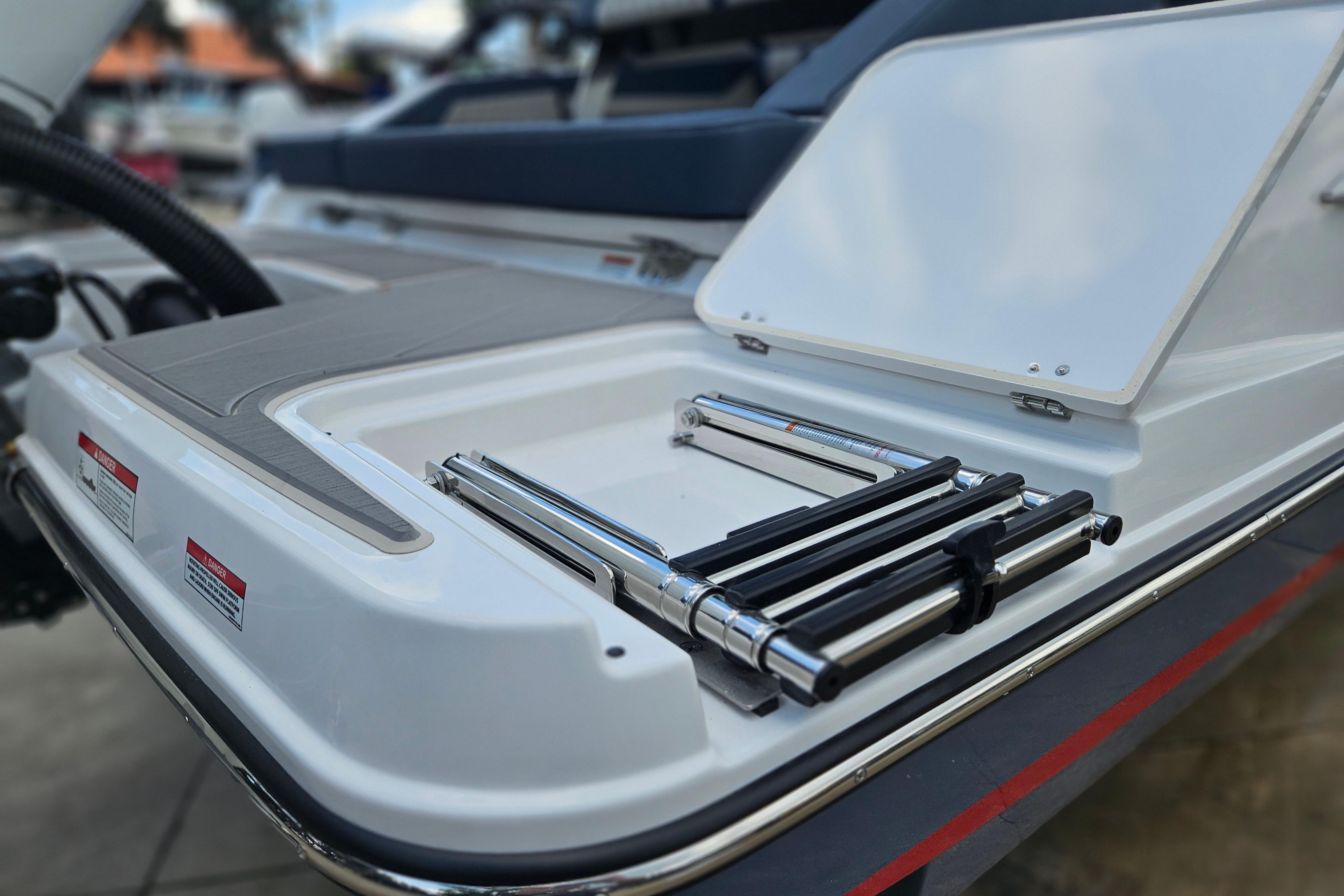 2026 Monterey Elite 27 OB boat with open storage compartment and ladder.