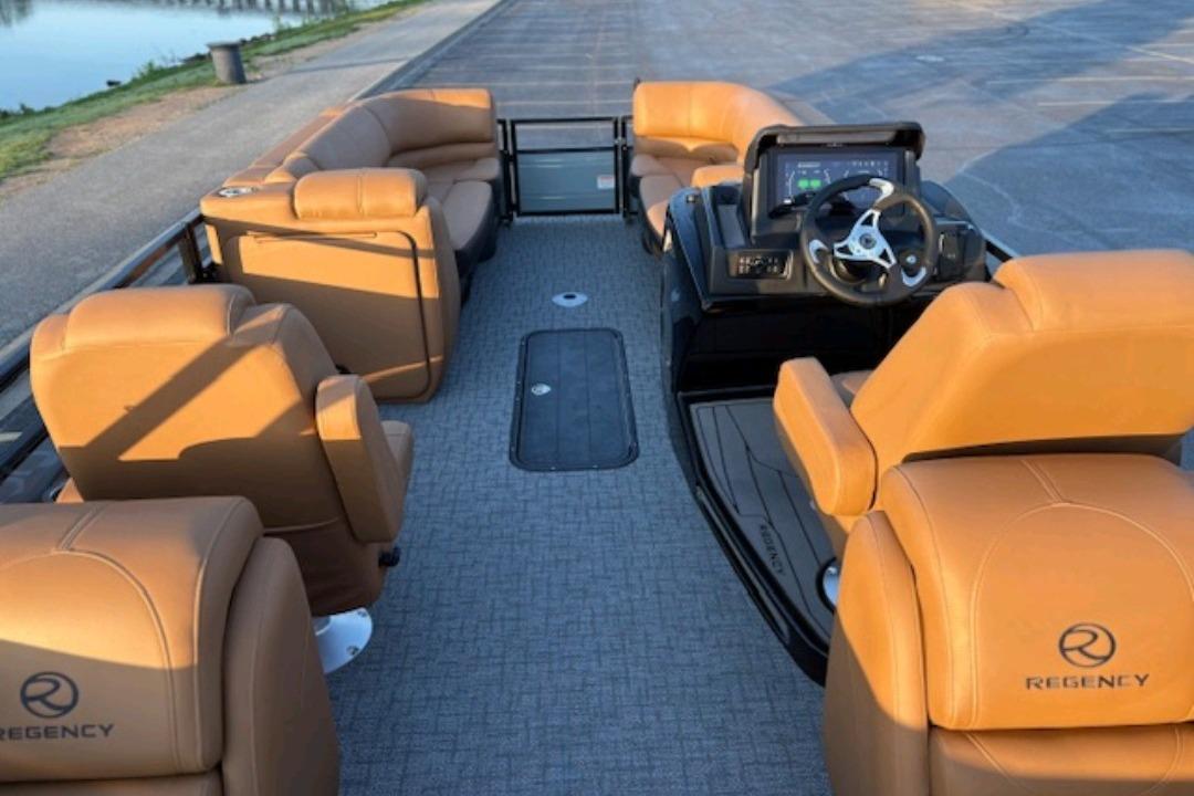 2026 Regency 230 DL pontoon boat interior with tan leather seating and modern dashboard.