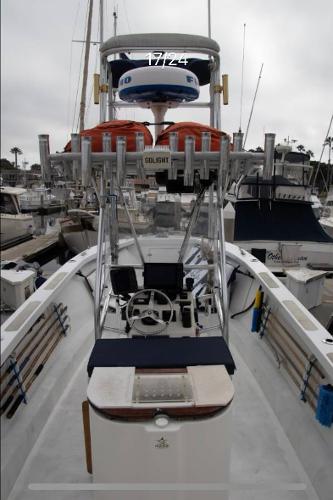 1979 Chaparral 224 Fisherman boat with fishing gear, docked in a marina.