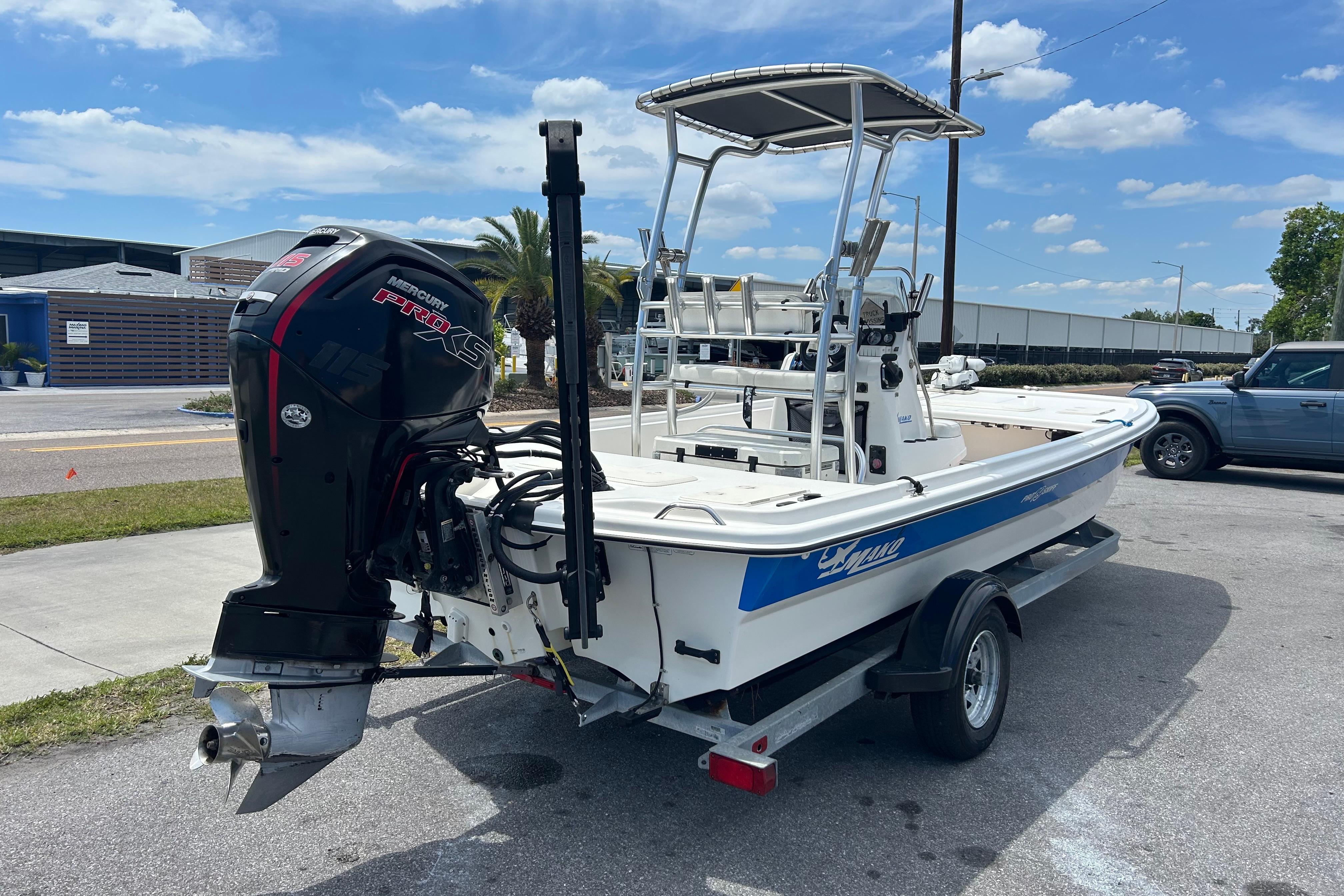 2021 Mako Pro Skiff 19 CC boat with Mercury engine on trailer, parked outdoors.