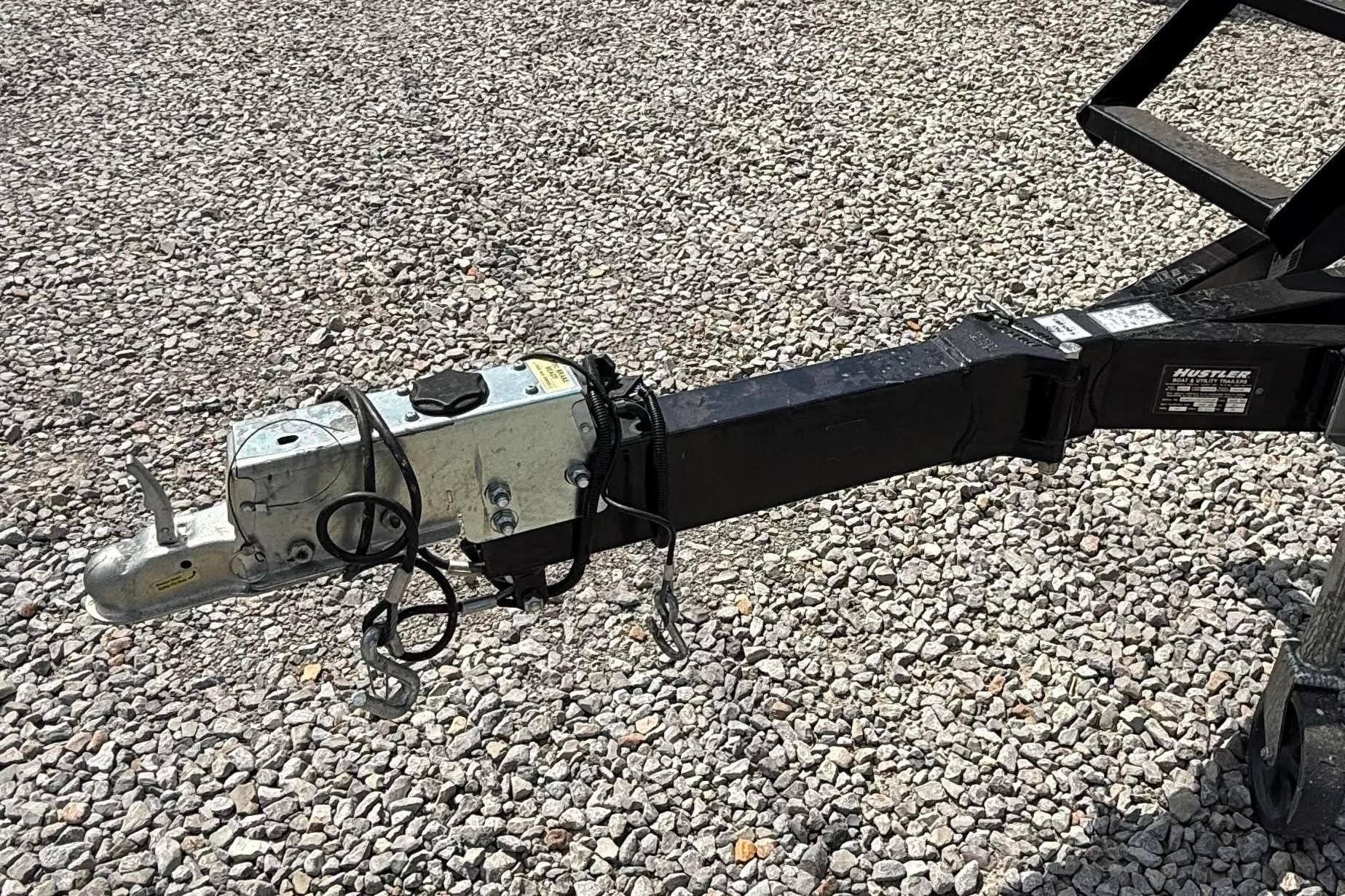 Trailer hitch of a 2022 Godfrey SWEETWATER 2486 on gravel surface.