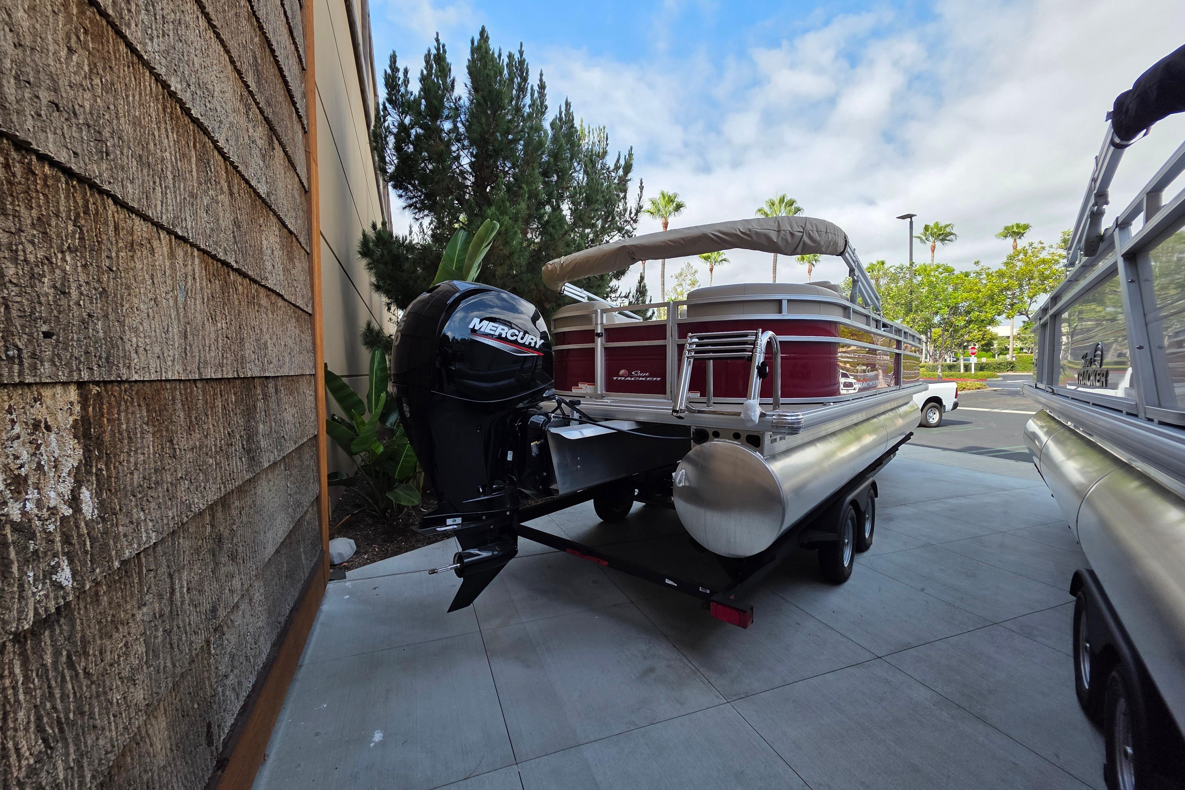 2025 Sun Tracker Party Barge 24 DLX pontoon boat with Mercury engine on trailer.